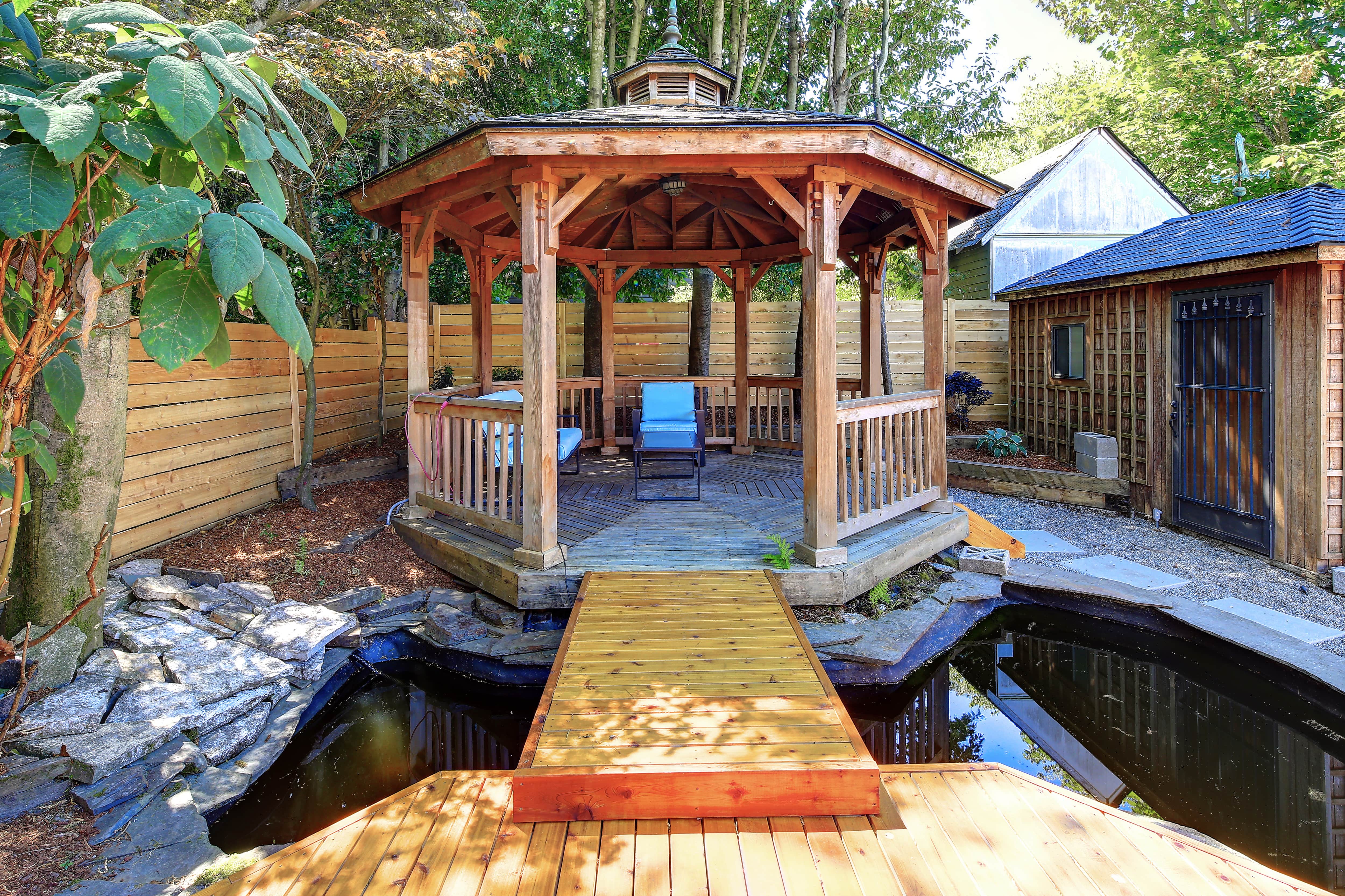 Bridge connecting wooden deck and gazebo in backyard