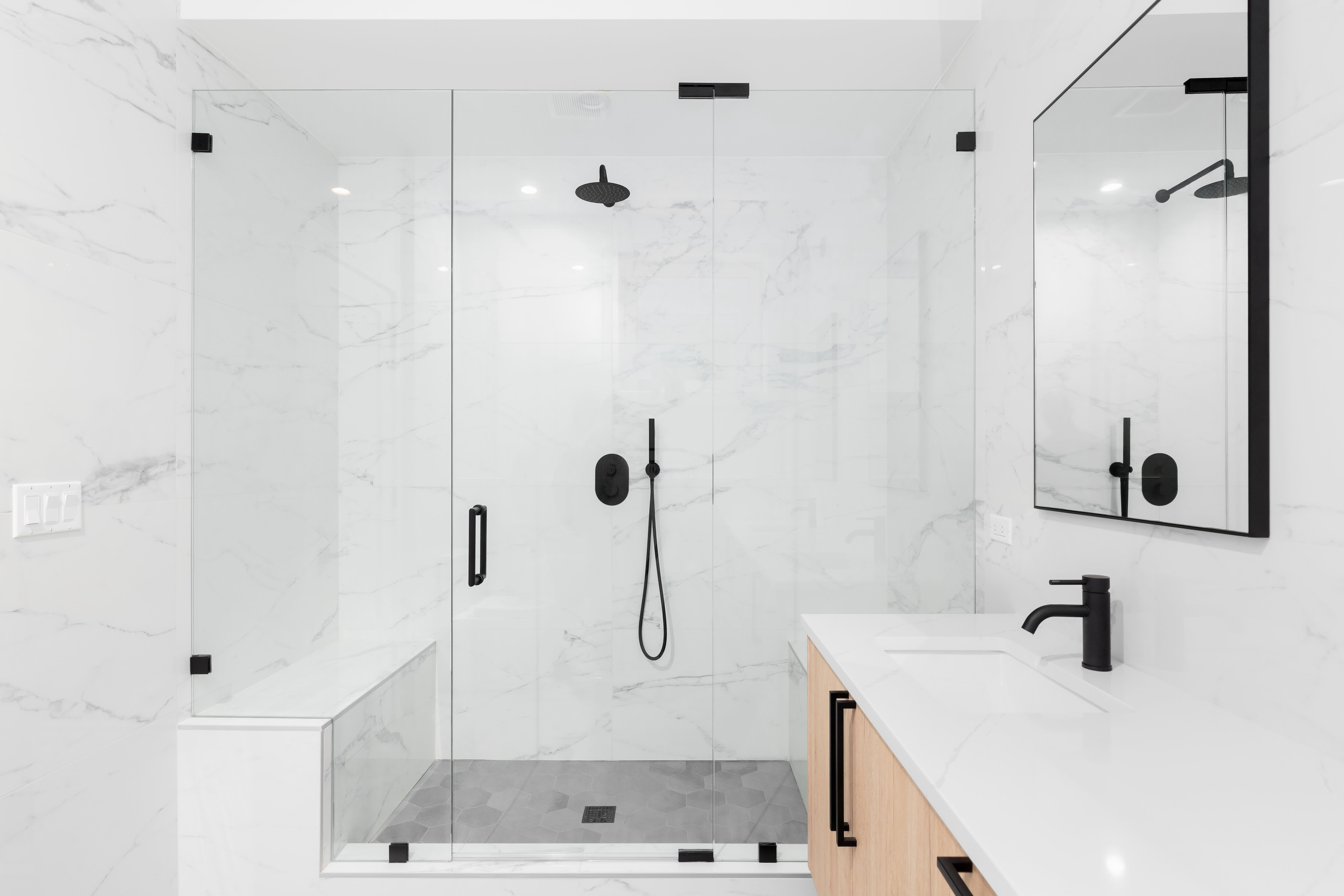 A black-and-white shower with a built-in bench