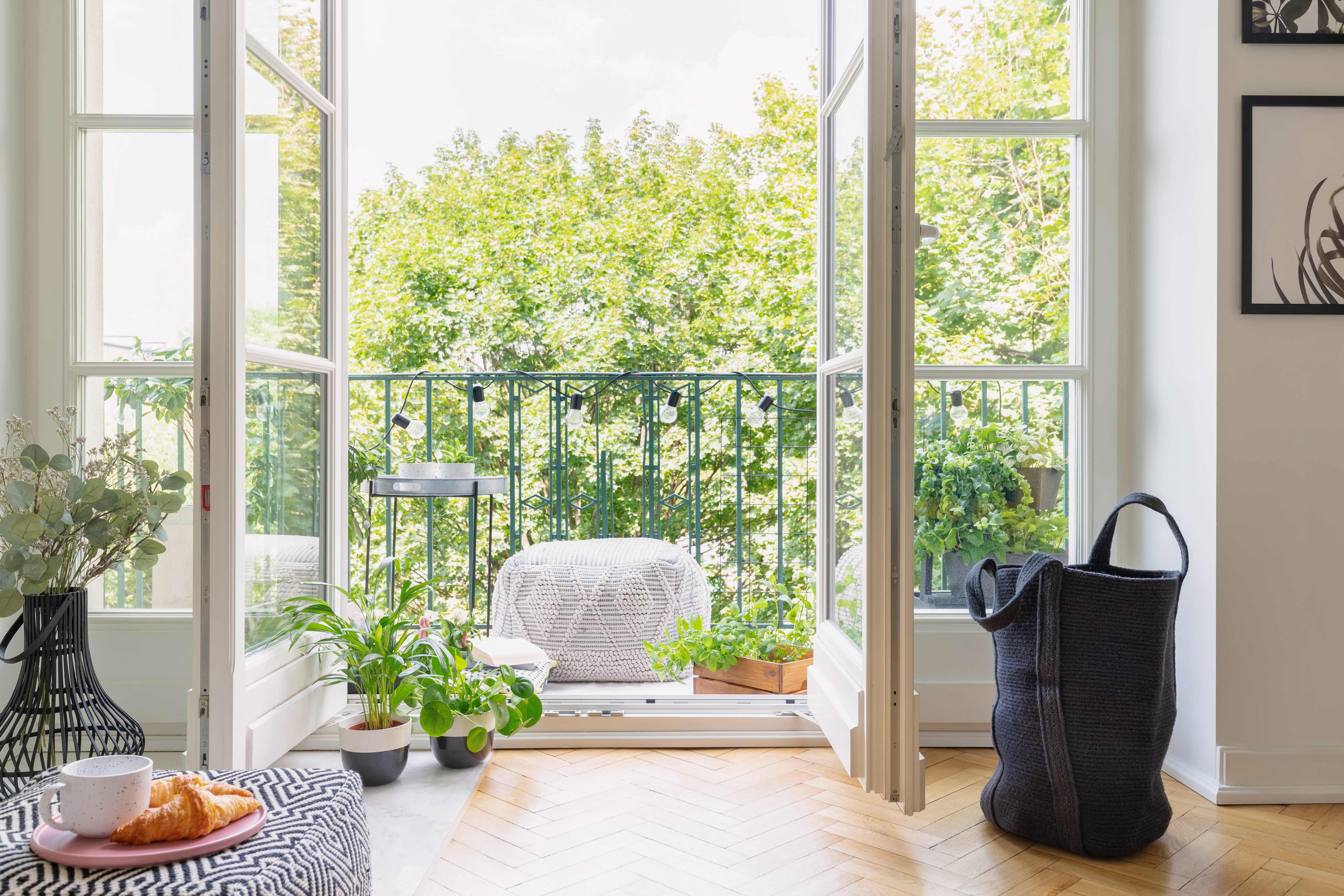Interior doors leading to outdoor balcony with pouf