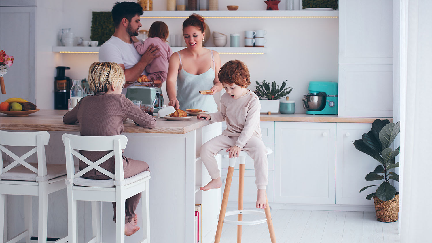 A family is gathered around a kitchen island