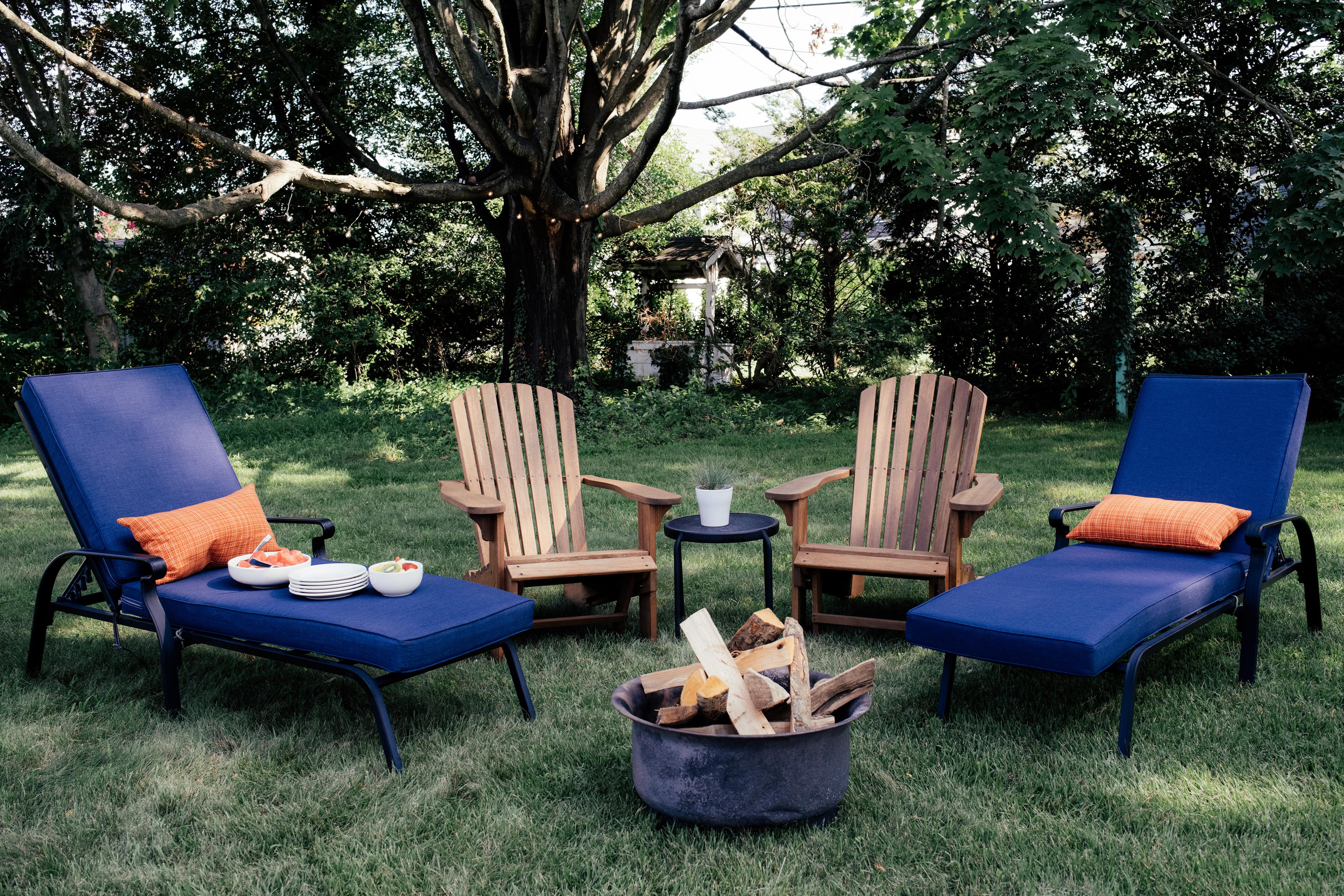 Adirondack chairs and blue lounge chairs surrounding fire pit