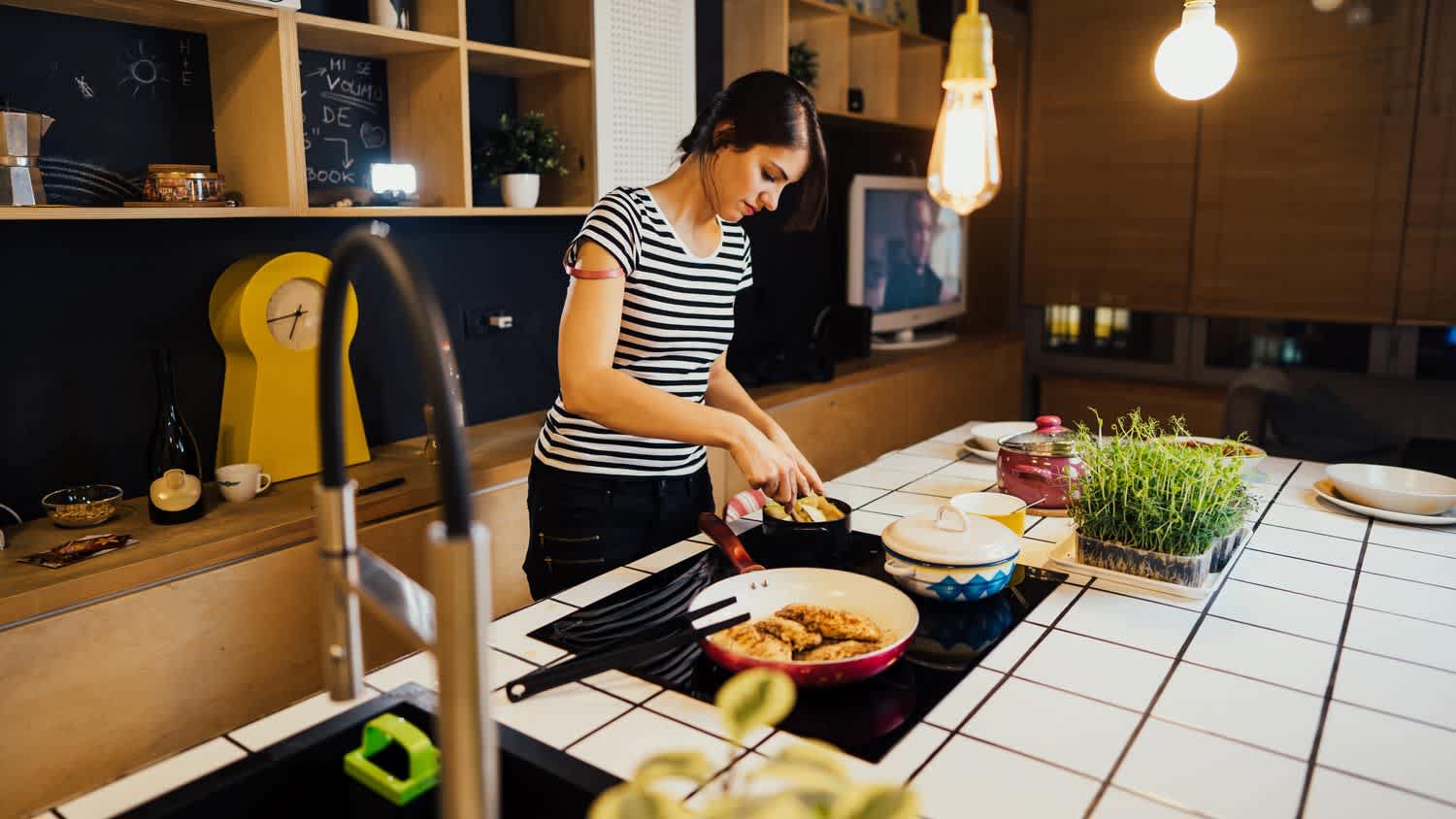 A woman cooking on a kitchen island