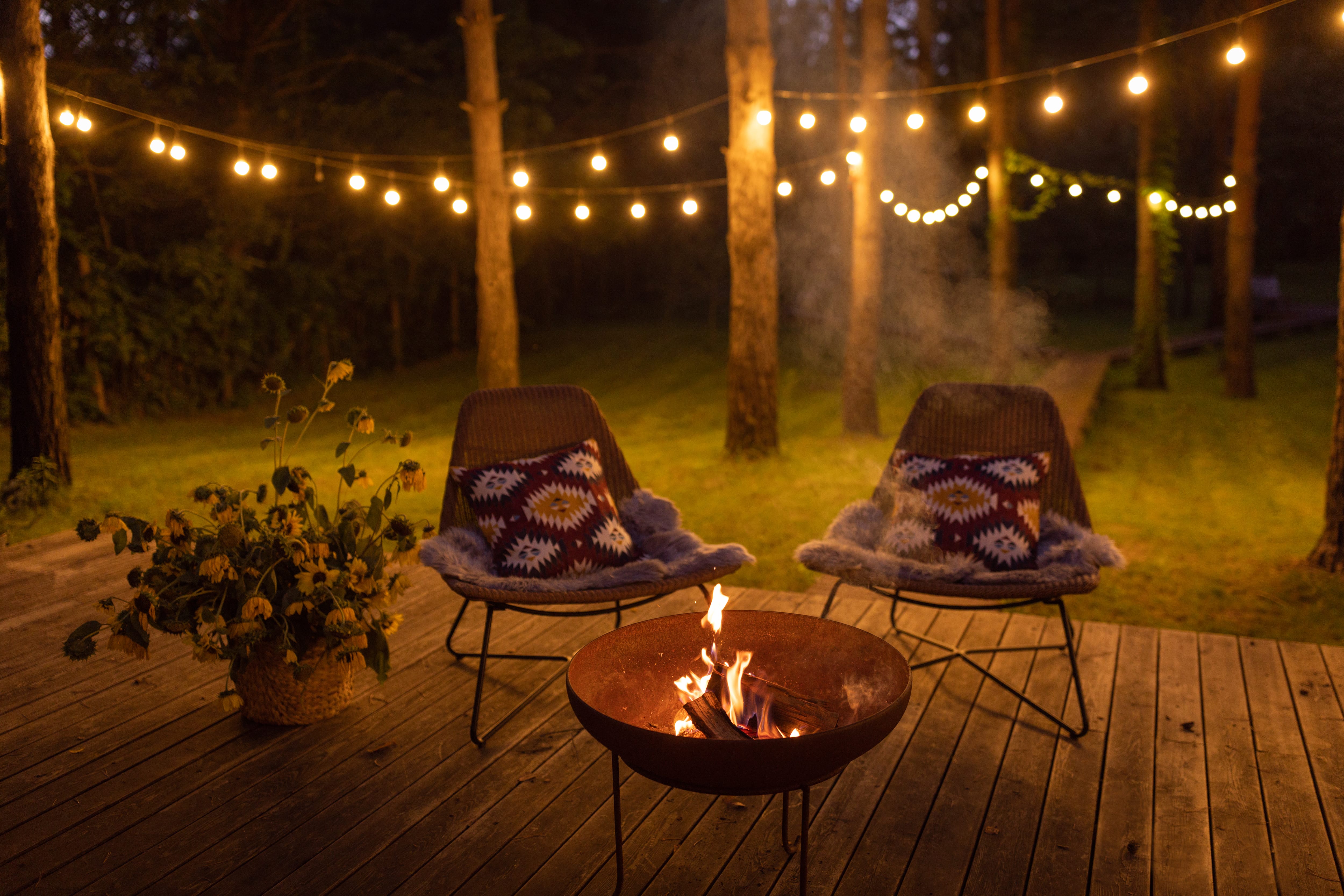 Steel bowl fire pit with metal and woven chairs