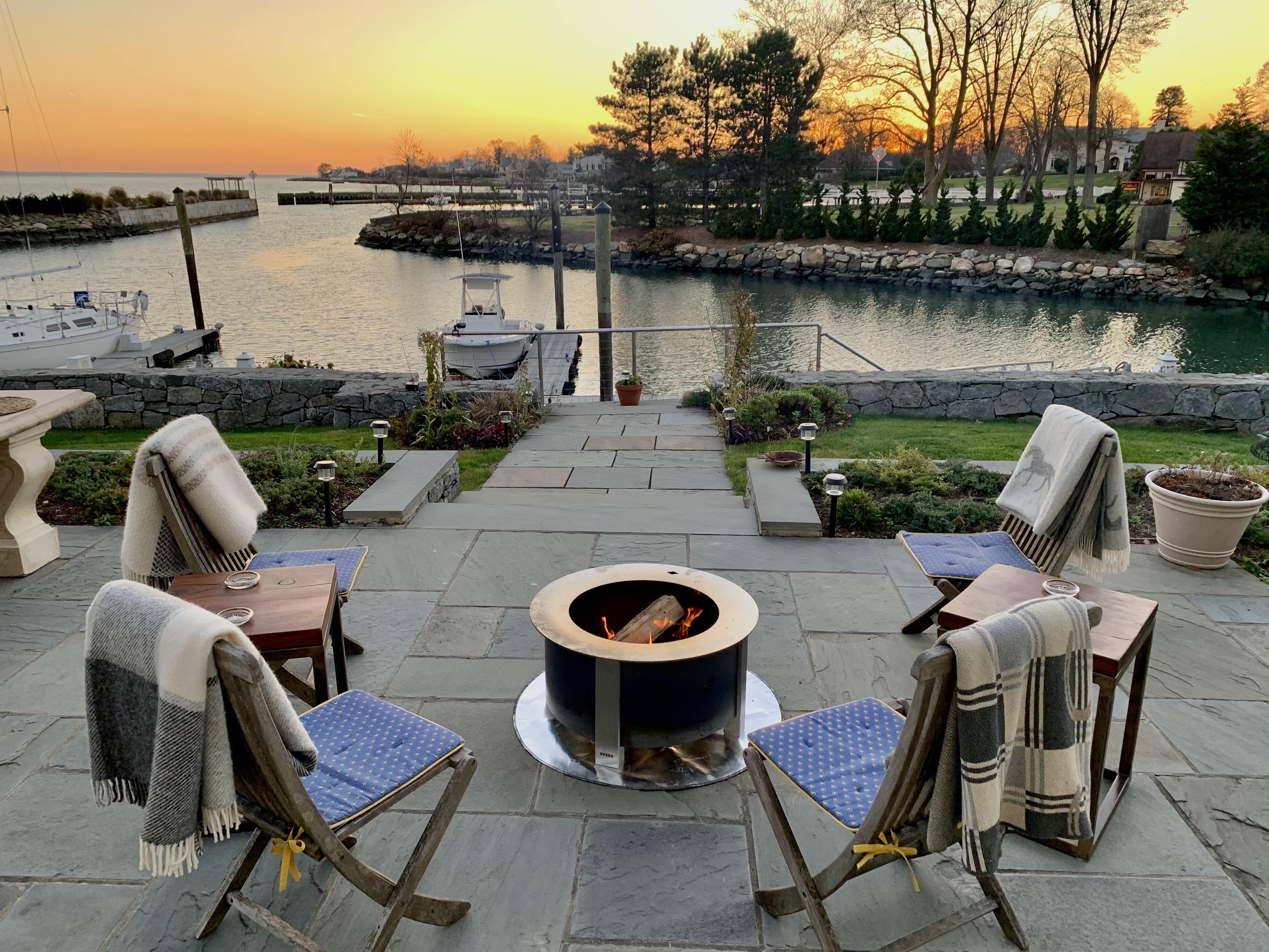 Blankets folded over patio chairs around fire pit