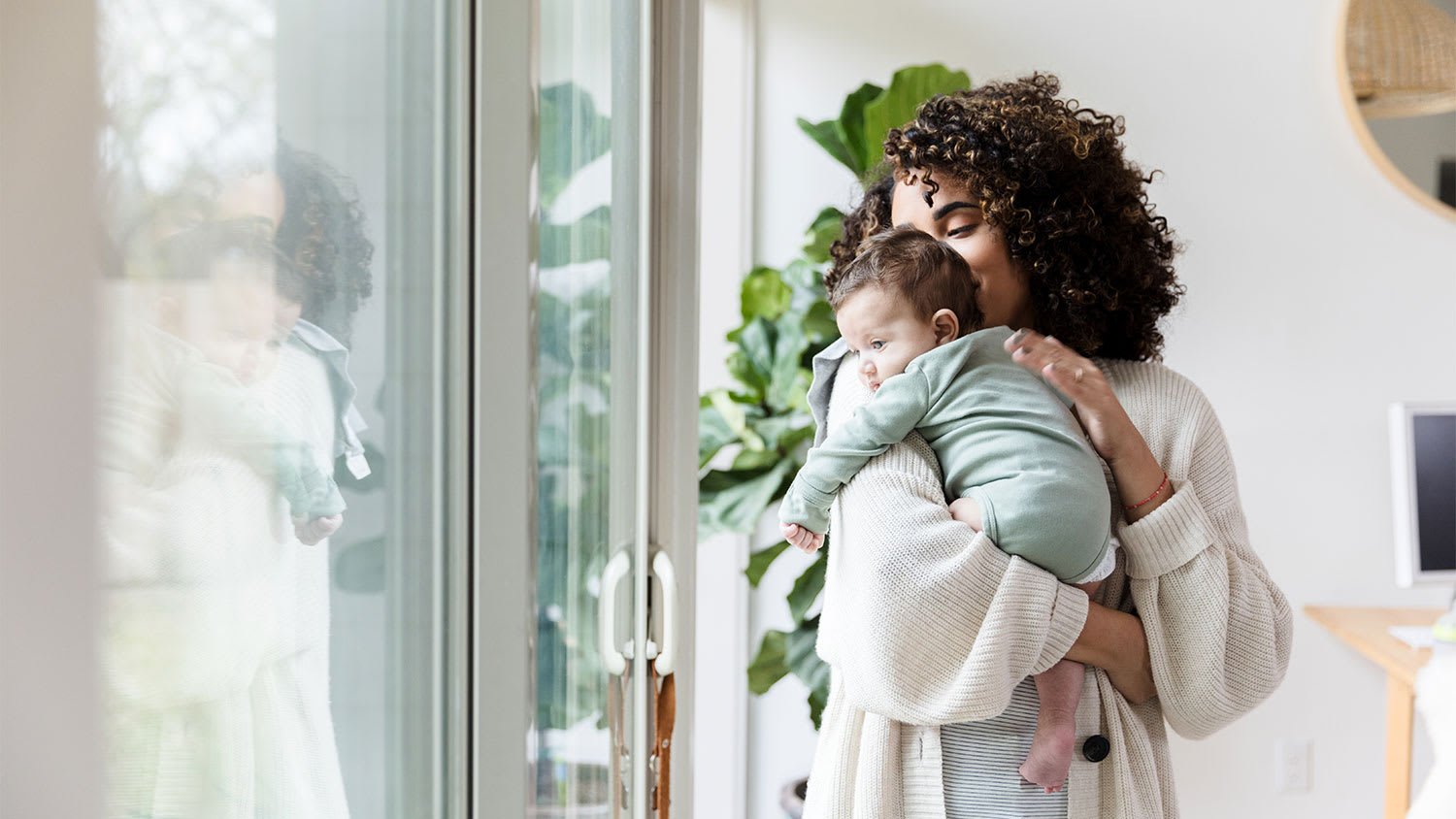 A mother and child stand in front of a sliding glass door
