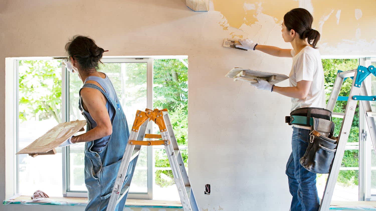 A family diy plastering a house wall