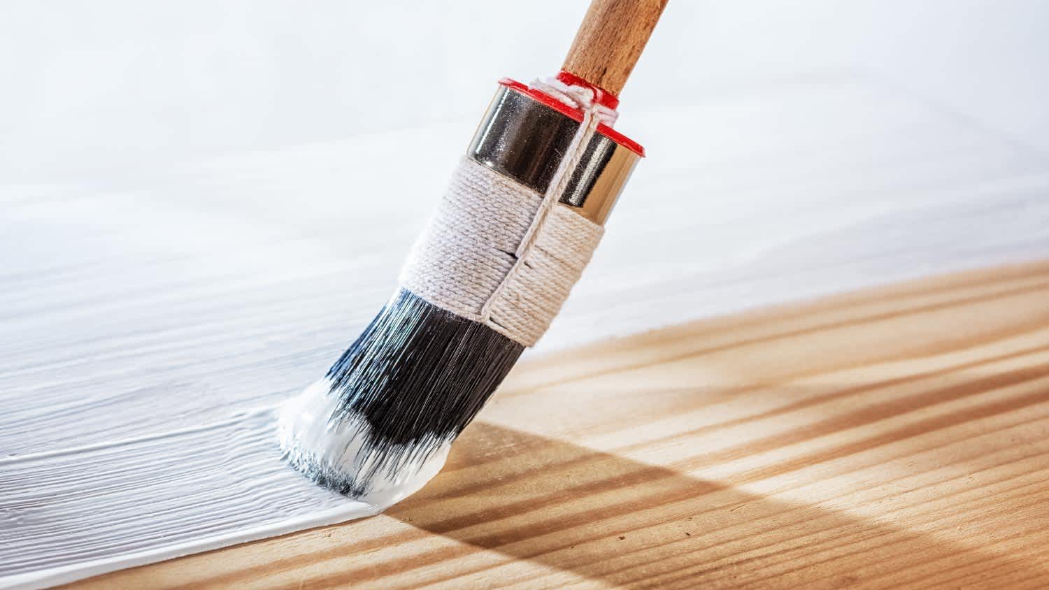 Applying white primer paint on wood
