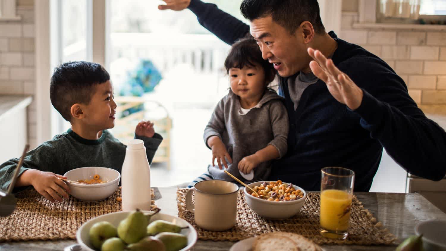 A father and his children having breakfast on the kitchen table