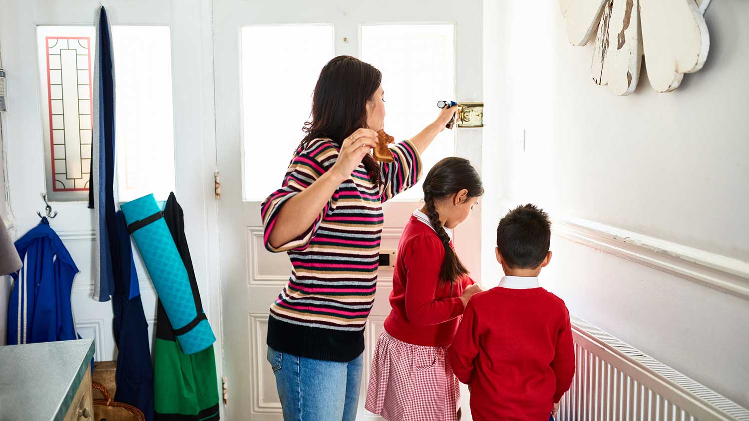 Mother opening front door to take children to school