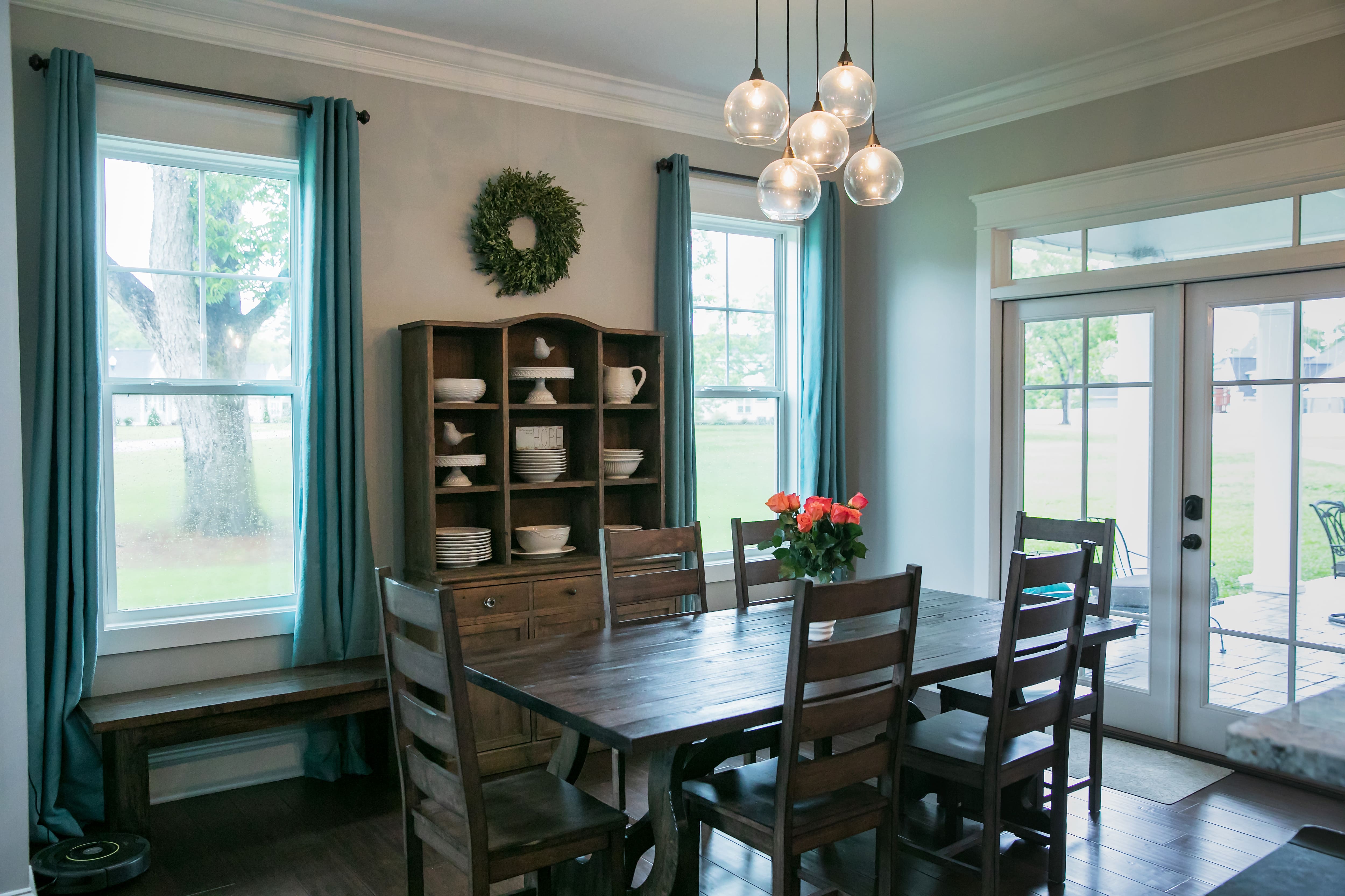 A modern rustic farmhouse dining room with globe pendant lights