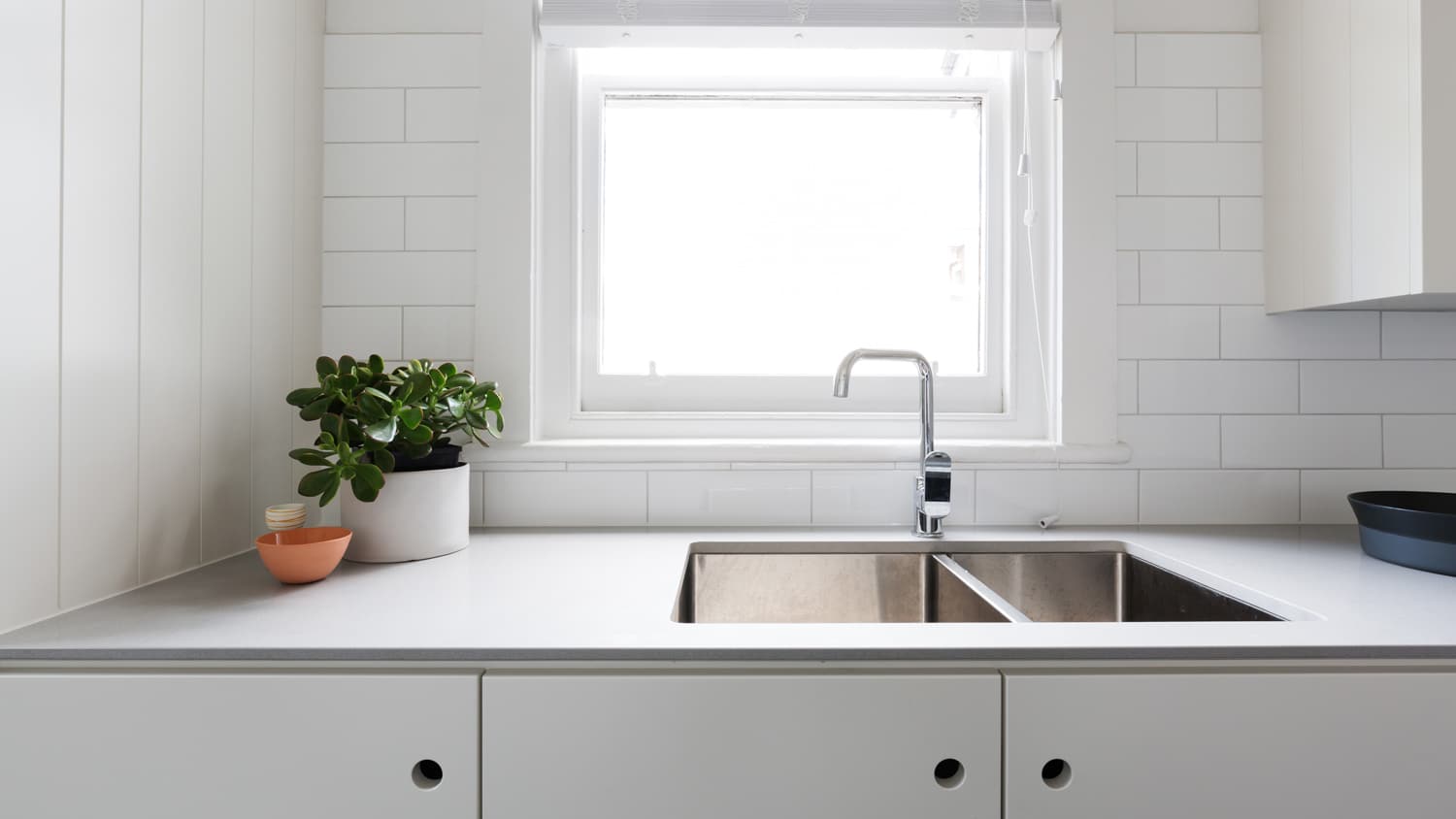 A contemporary white kitchen with laminate countertop