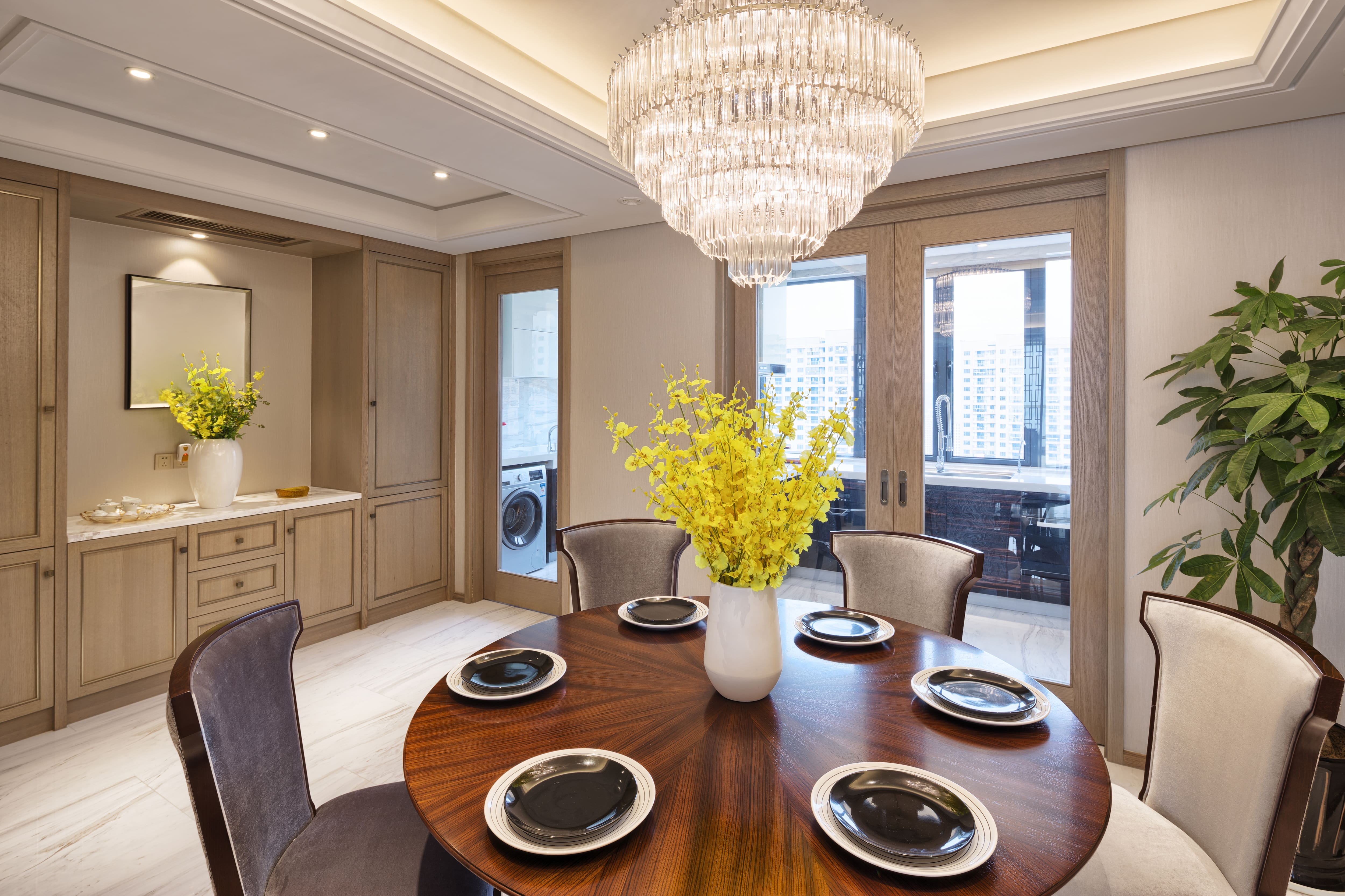 A crystal chandelier above a circular dining room table