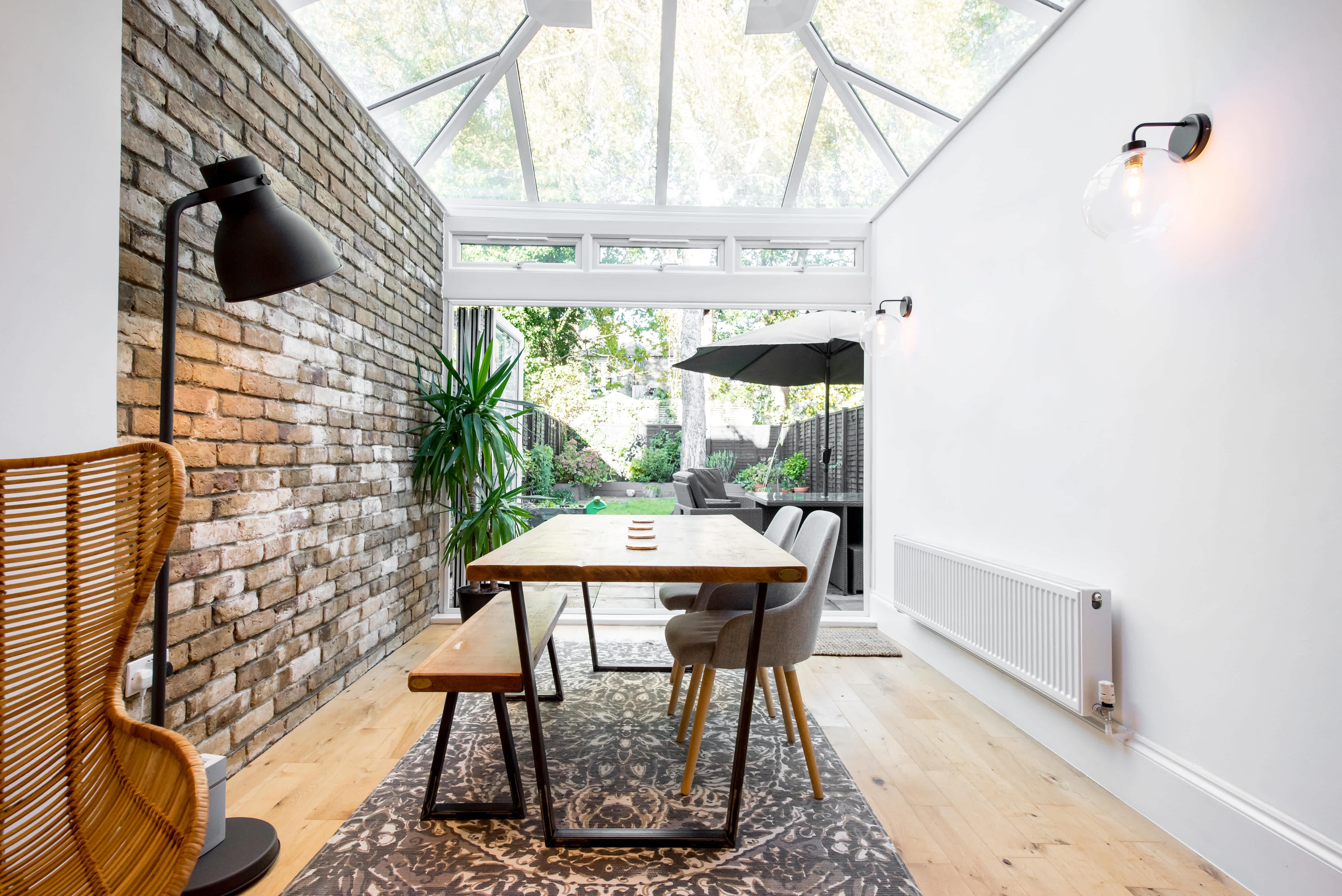 Dining room with a brick wall and glass wall sconces