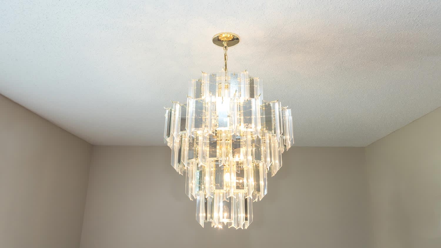 A chandelier hanged from a popcorn ceiling