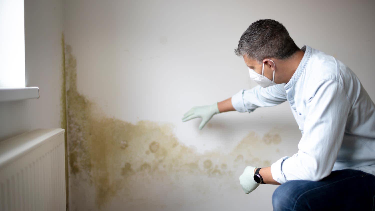 Man in front of white wall with mold