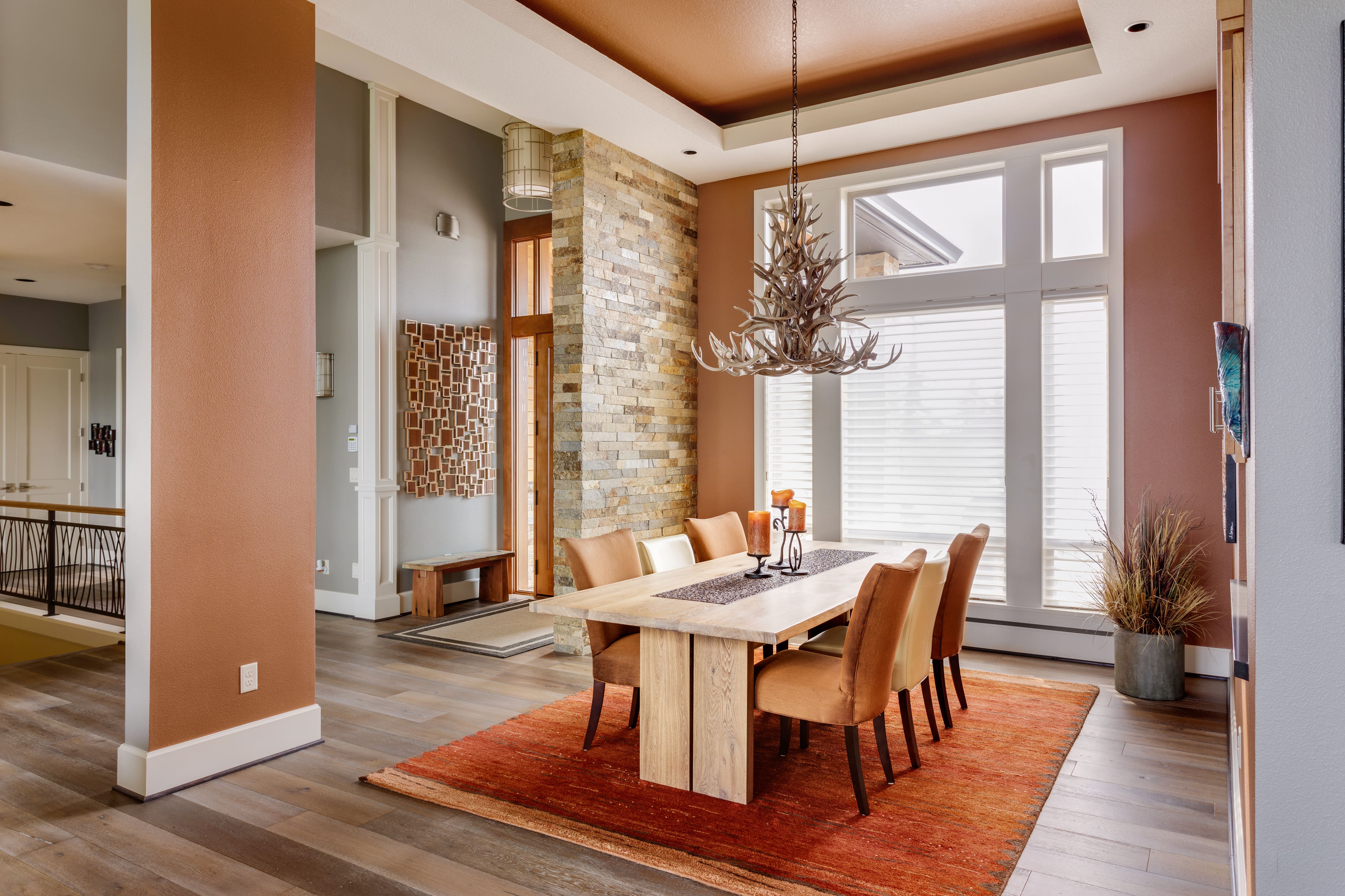 A brown and red dining room with a chandelier made of antlers