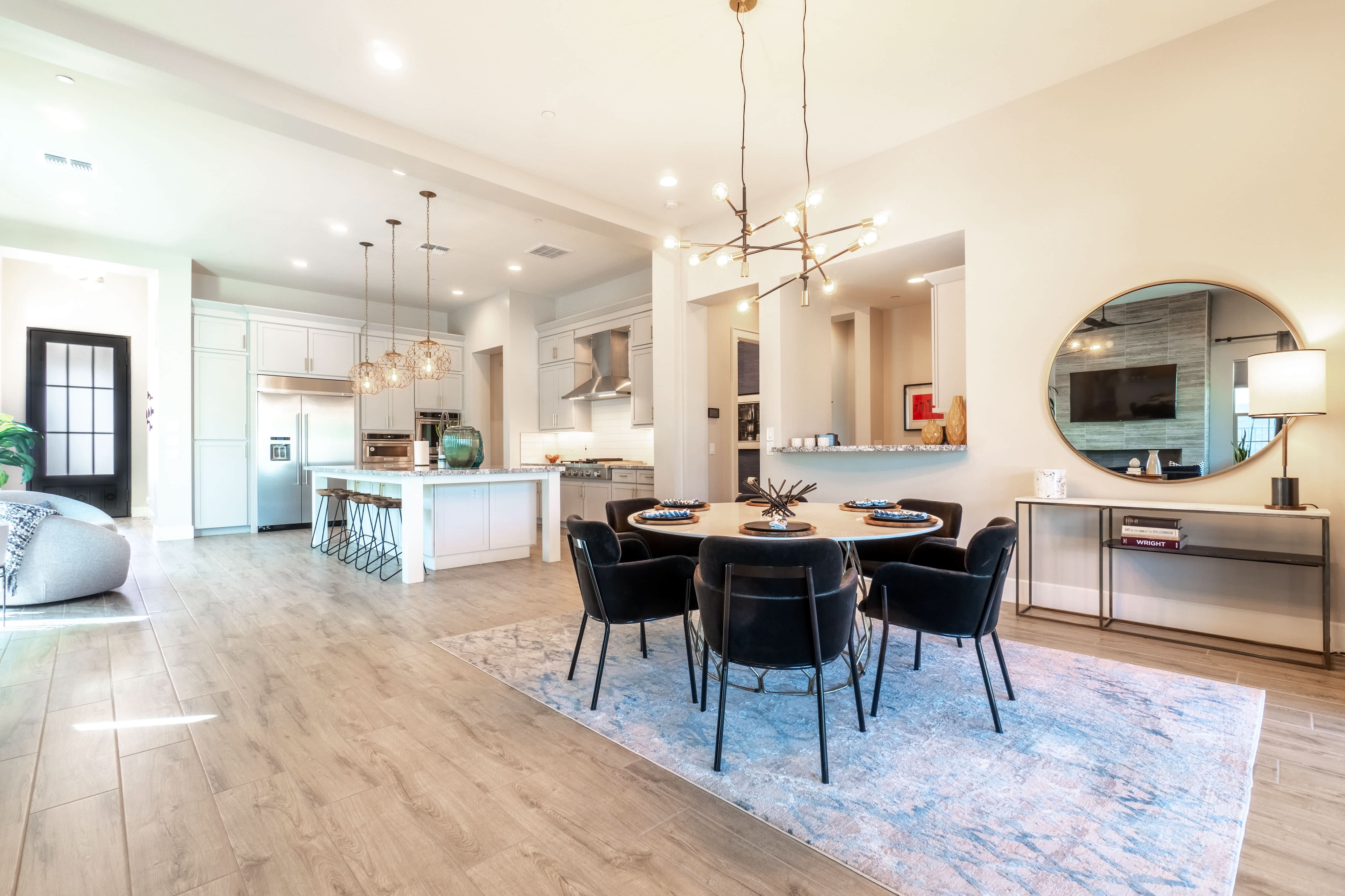 Modern dining room with black chairs, round wood table, and pastel rug