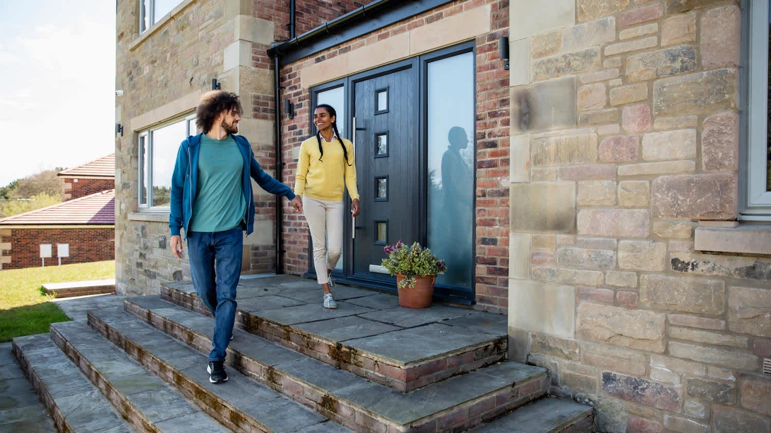 A couple exiting their home through their front door