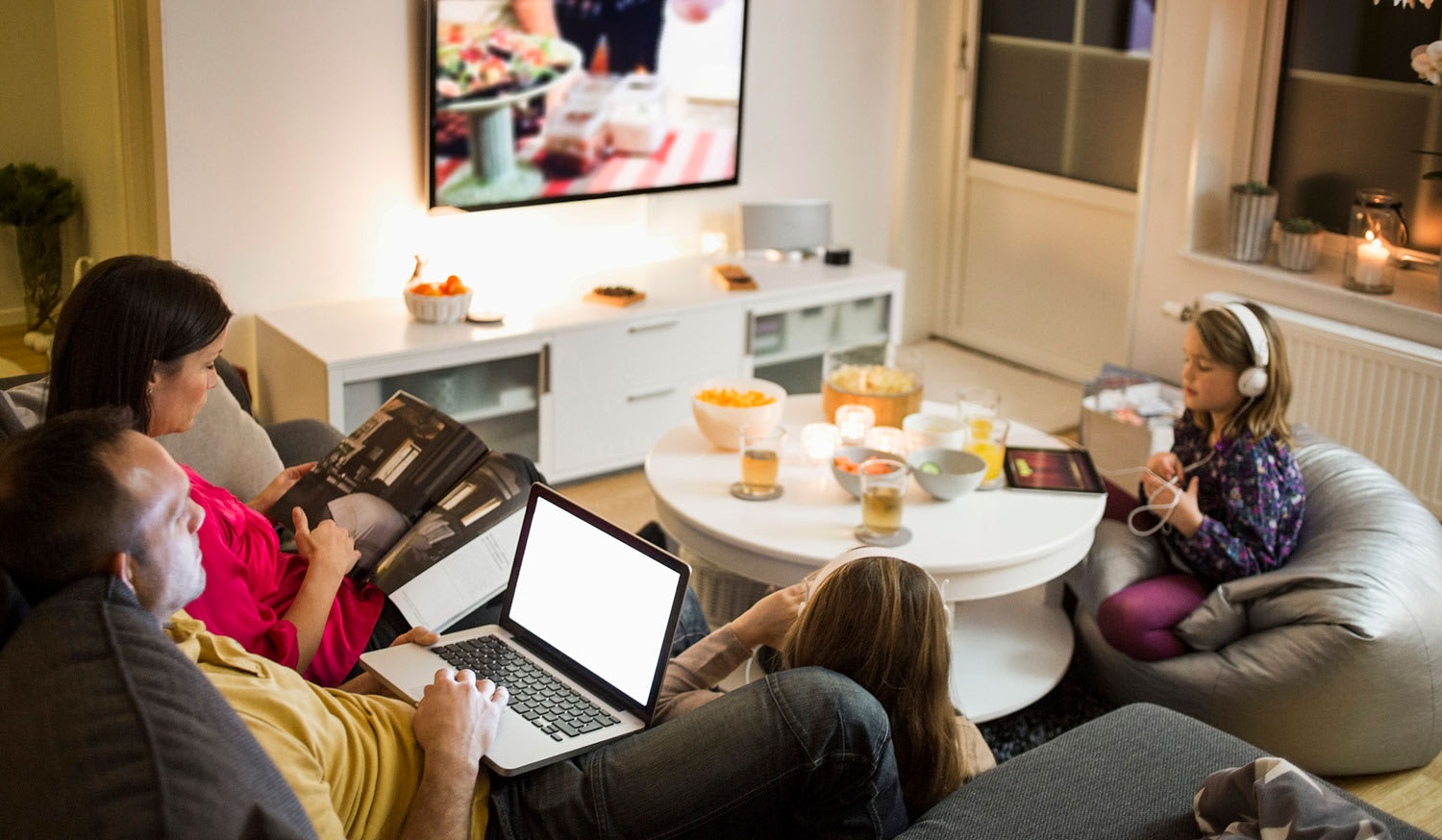 Family watches TV and play on electronics