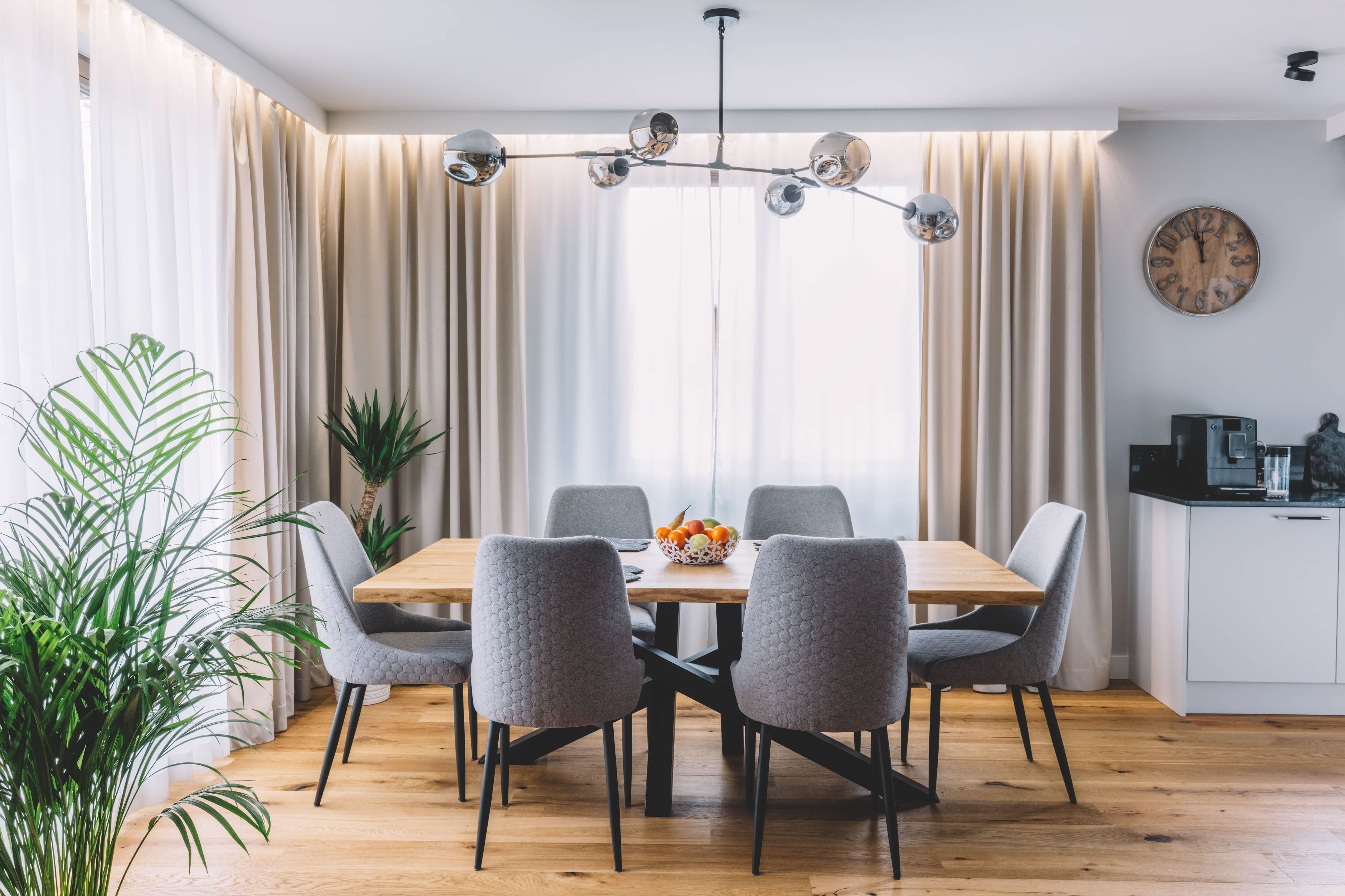 A dining room with a silver branch chandelier above the table
