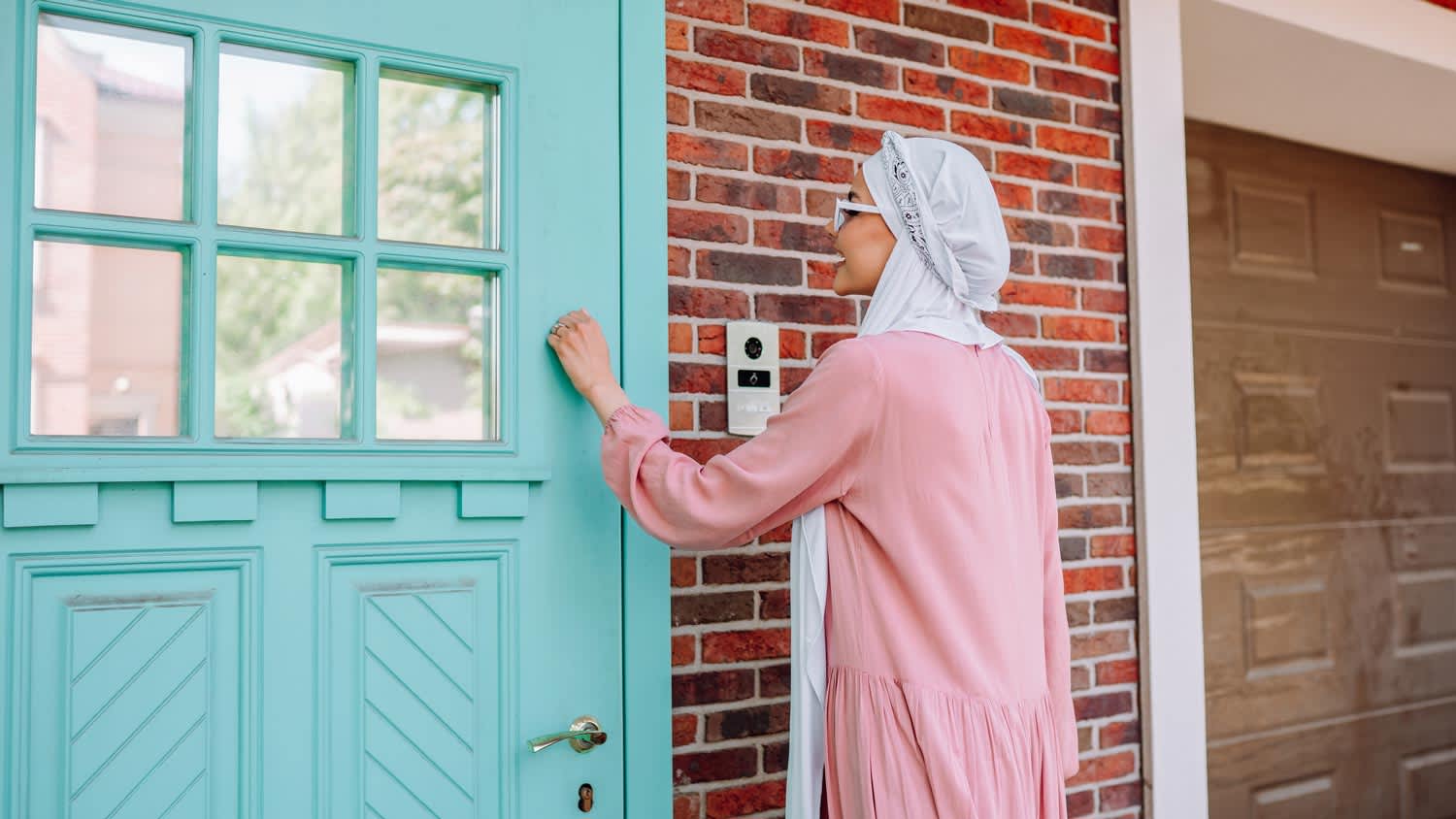 A young woman knocking on a front door