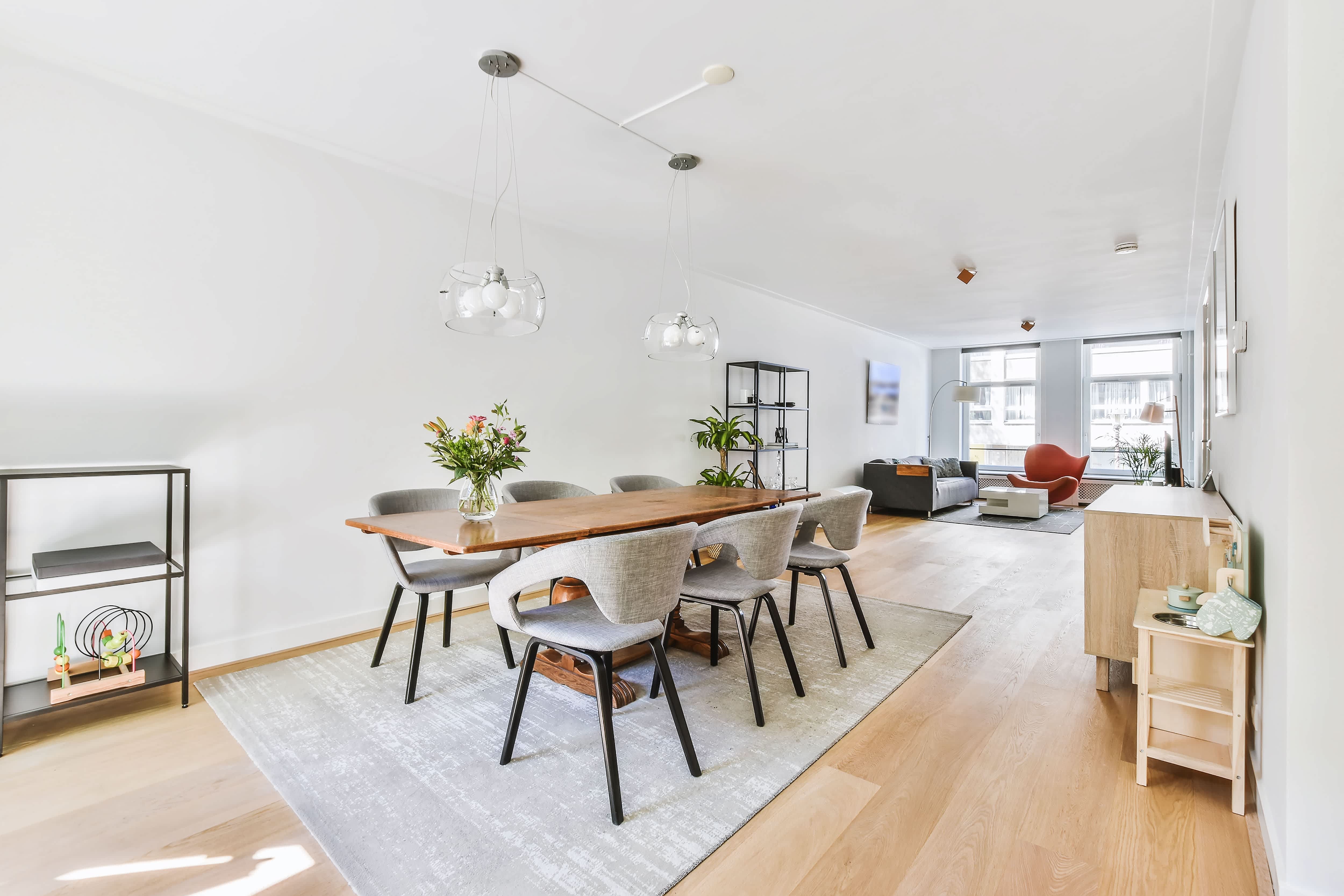 Open-concept condo with modern dining table and padded gray chairs