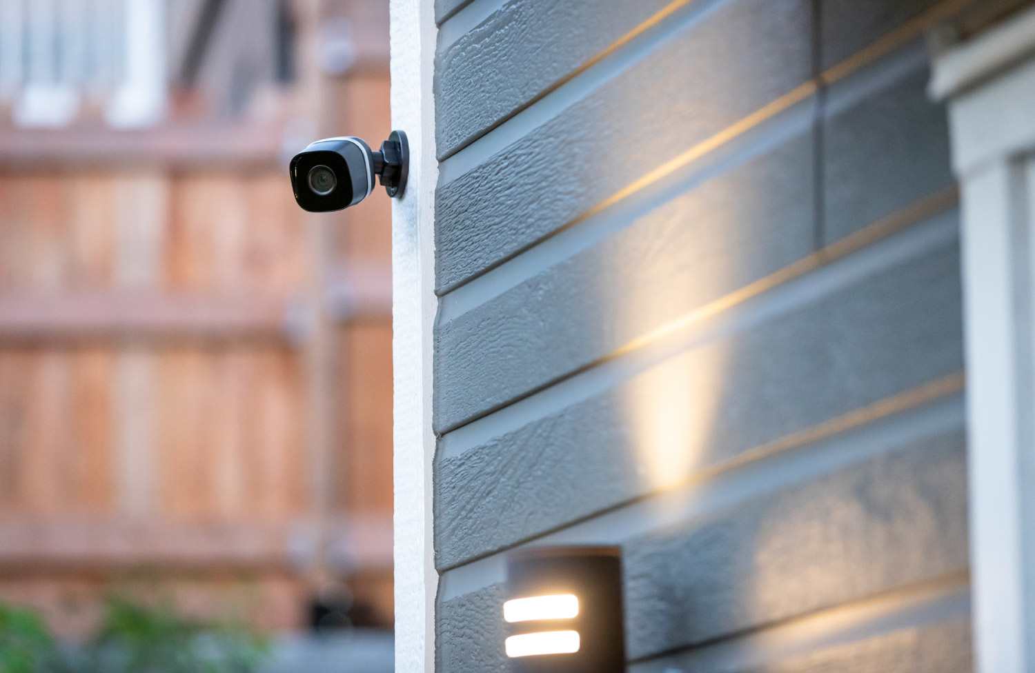 Black surveillance camera outside a house