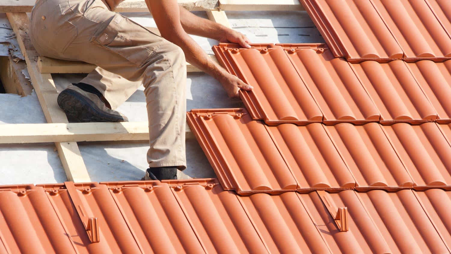 A man installing a tile roof