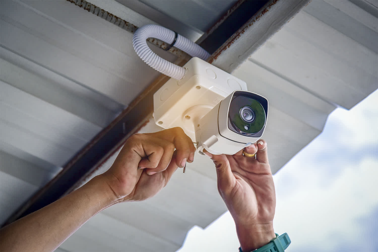 Person installing exterior home security camera