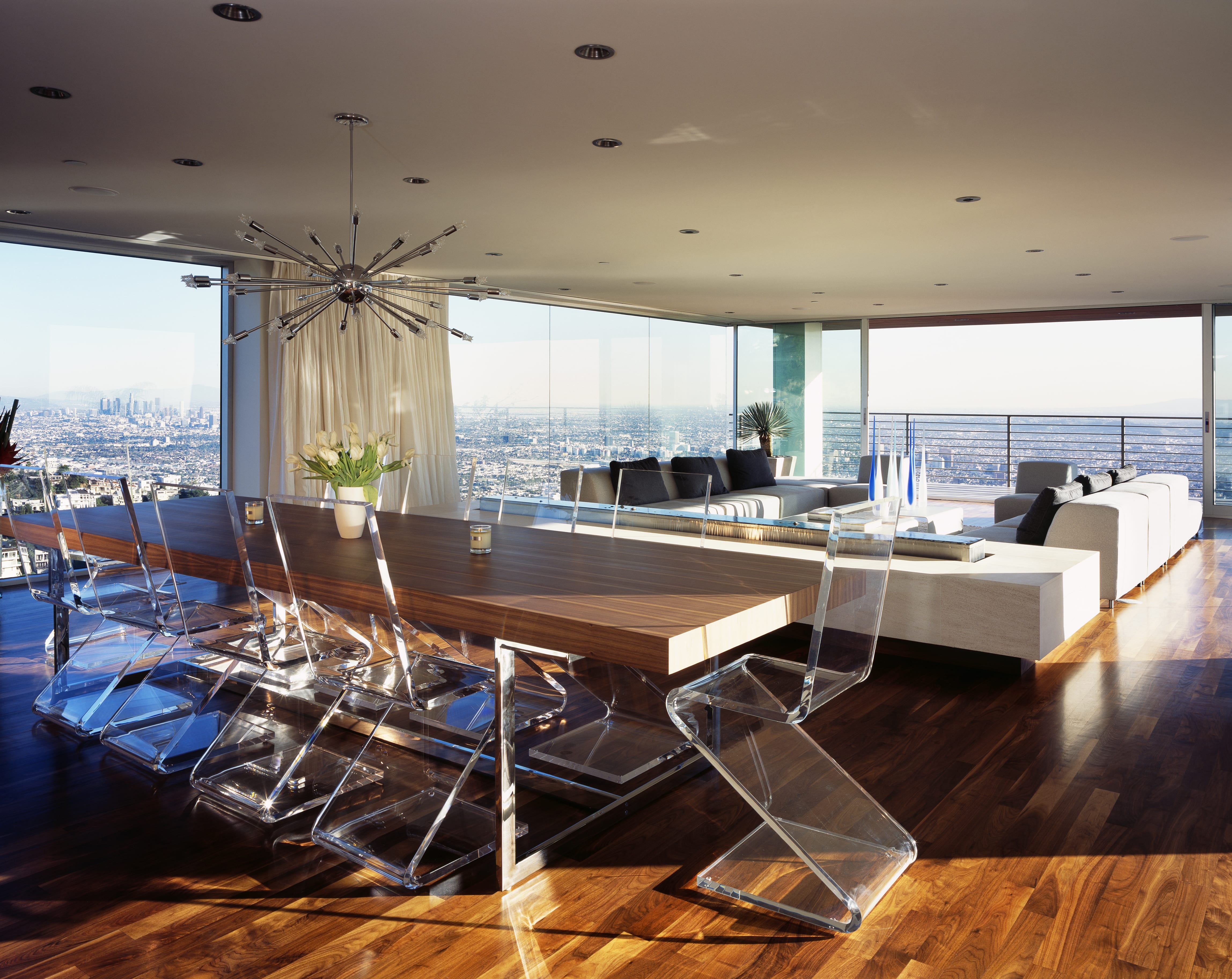 A open-floor plan modern dining and living room with a Sputnik chandelier