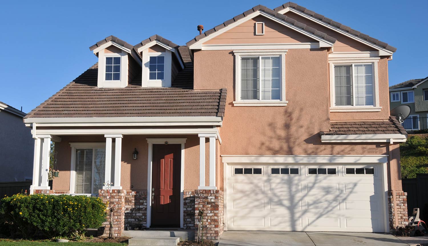 Stucco and brick house with maroon door