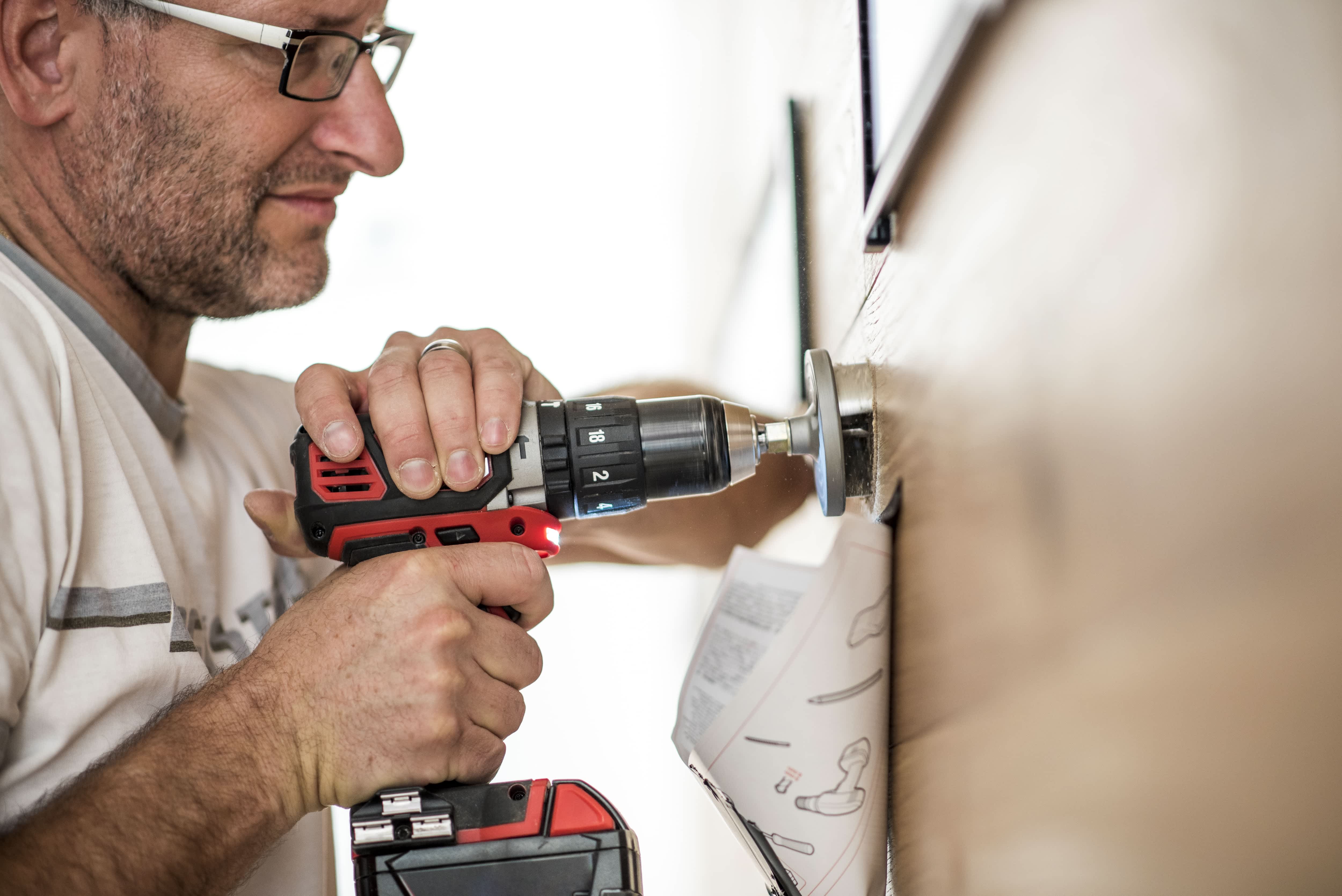A man with safety glasses installing hardware on a door