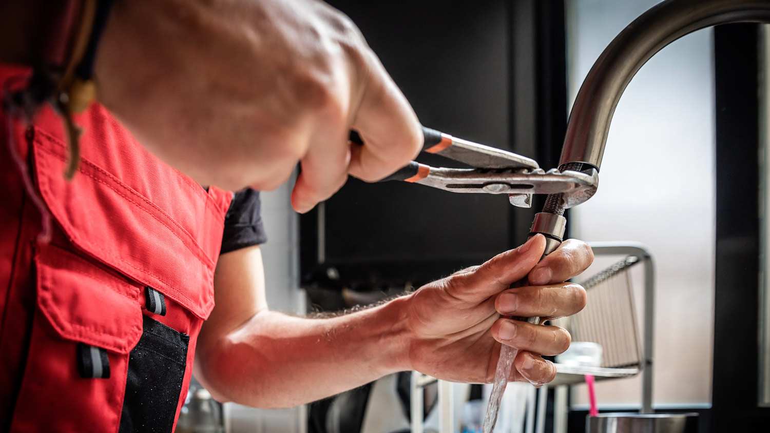 A plumber fixing a dripping faucet