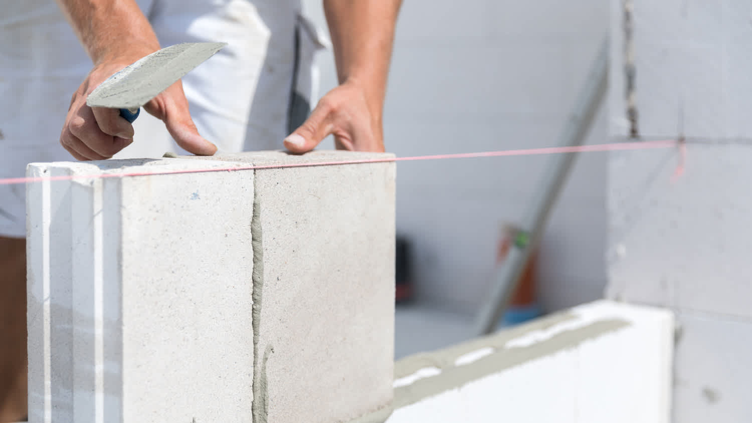 A worker installing concrete blocks