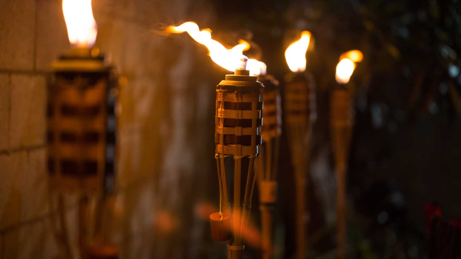lit tiki torches at night