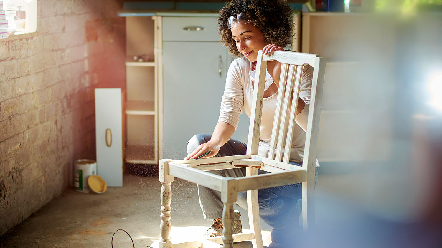 A woman repairs a wooden chair