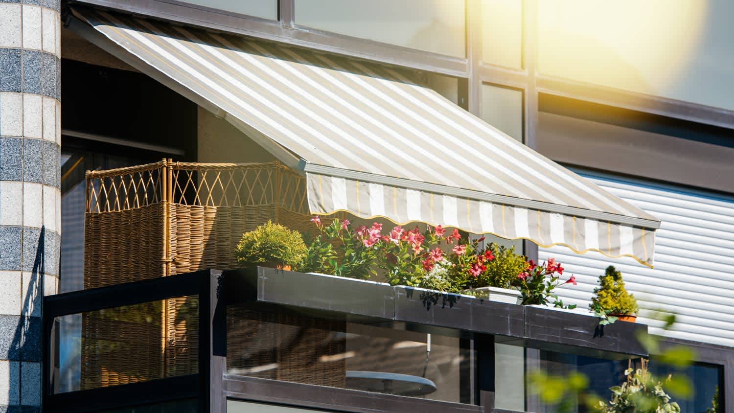 Beautiful balcony with flowers and retractable awnings