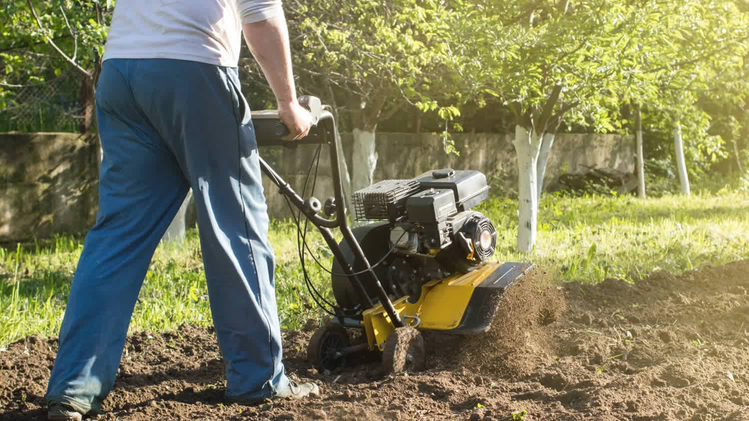 A man plowing a soil by motor cultivator