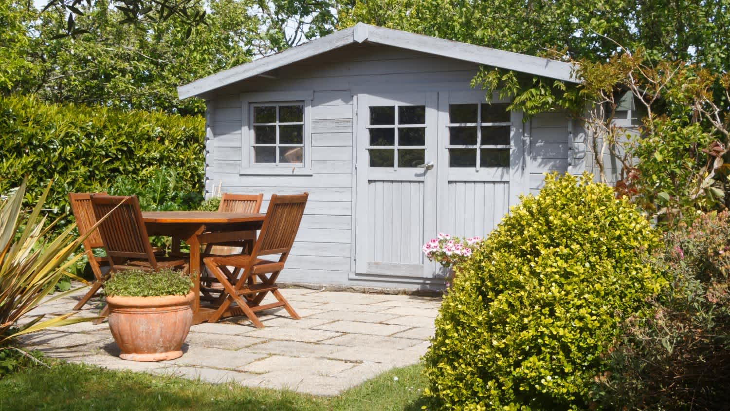 A shed with terrace and wooden garden furniture