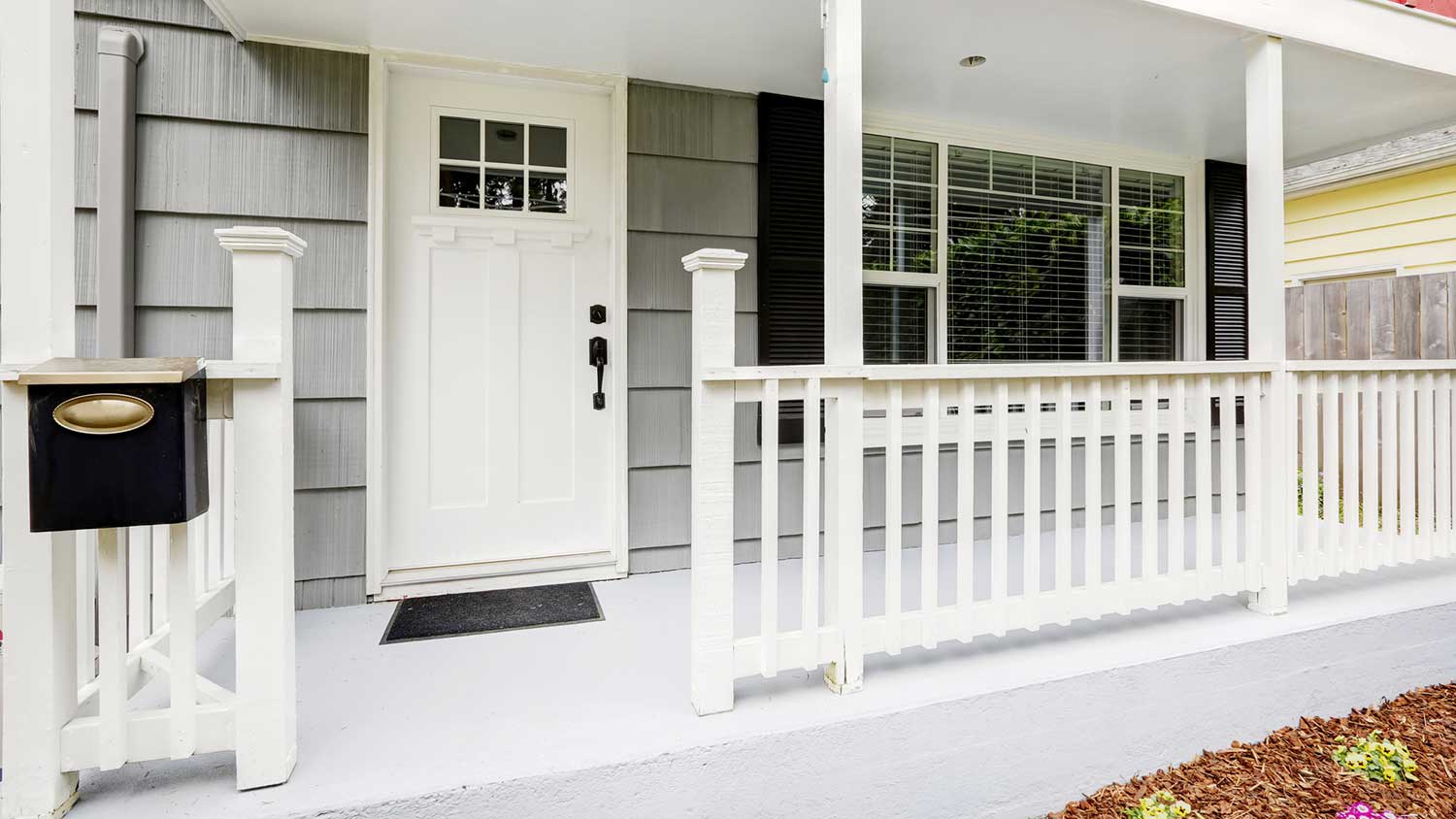 Front porch with white fence and concrete floor
