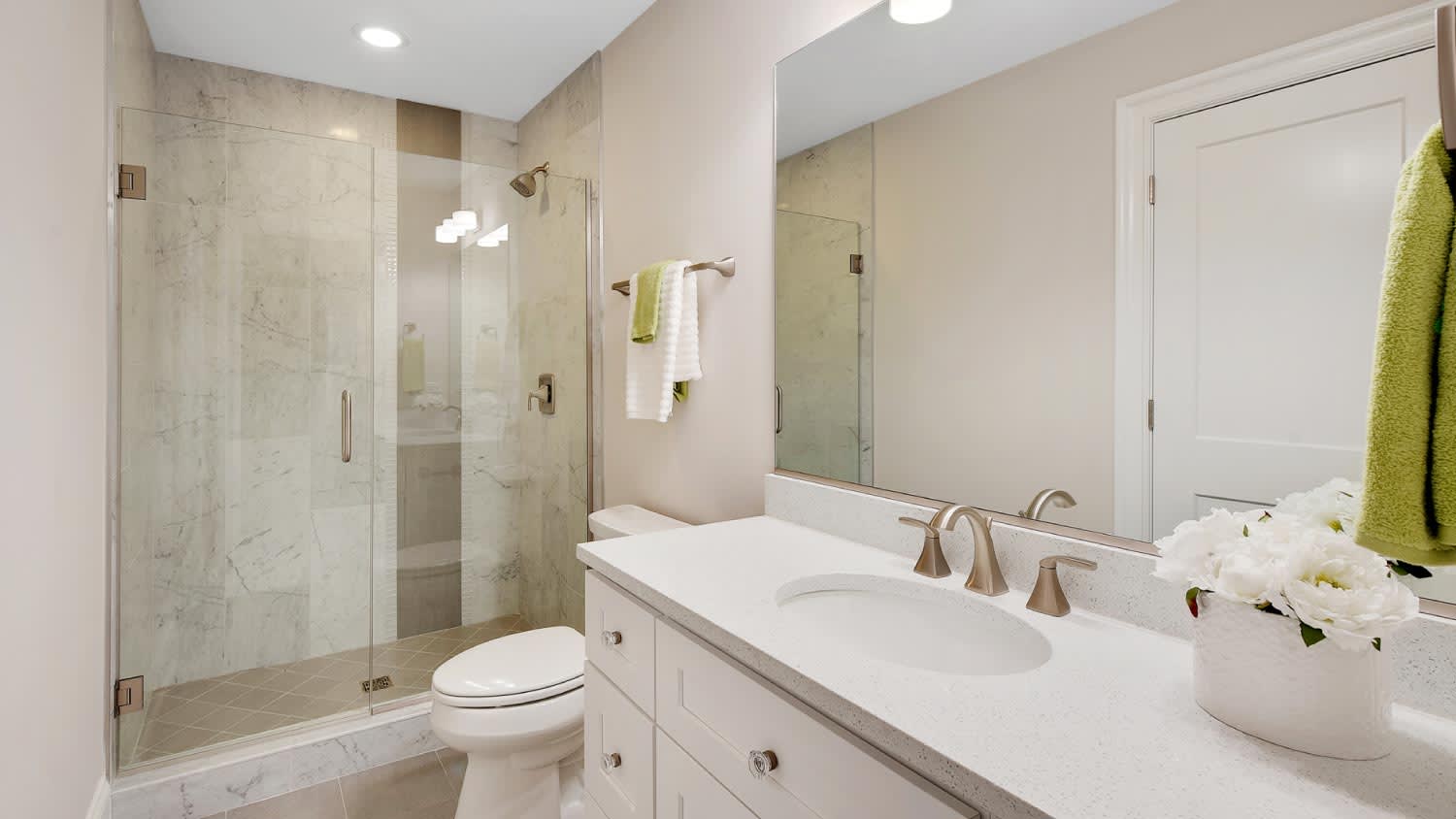 A bright bathroom with glass shower