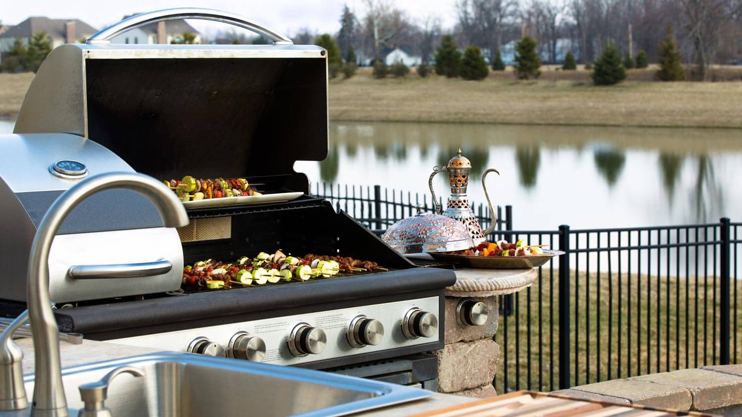 An outdoor kitchen with a barbeque and a sink