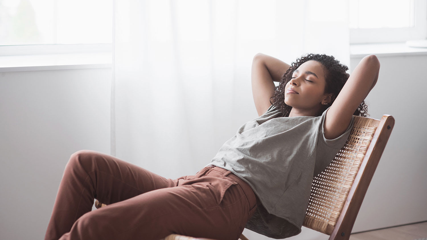 Woman sitting on a chair is relaxing by the window