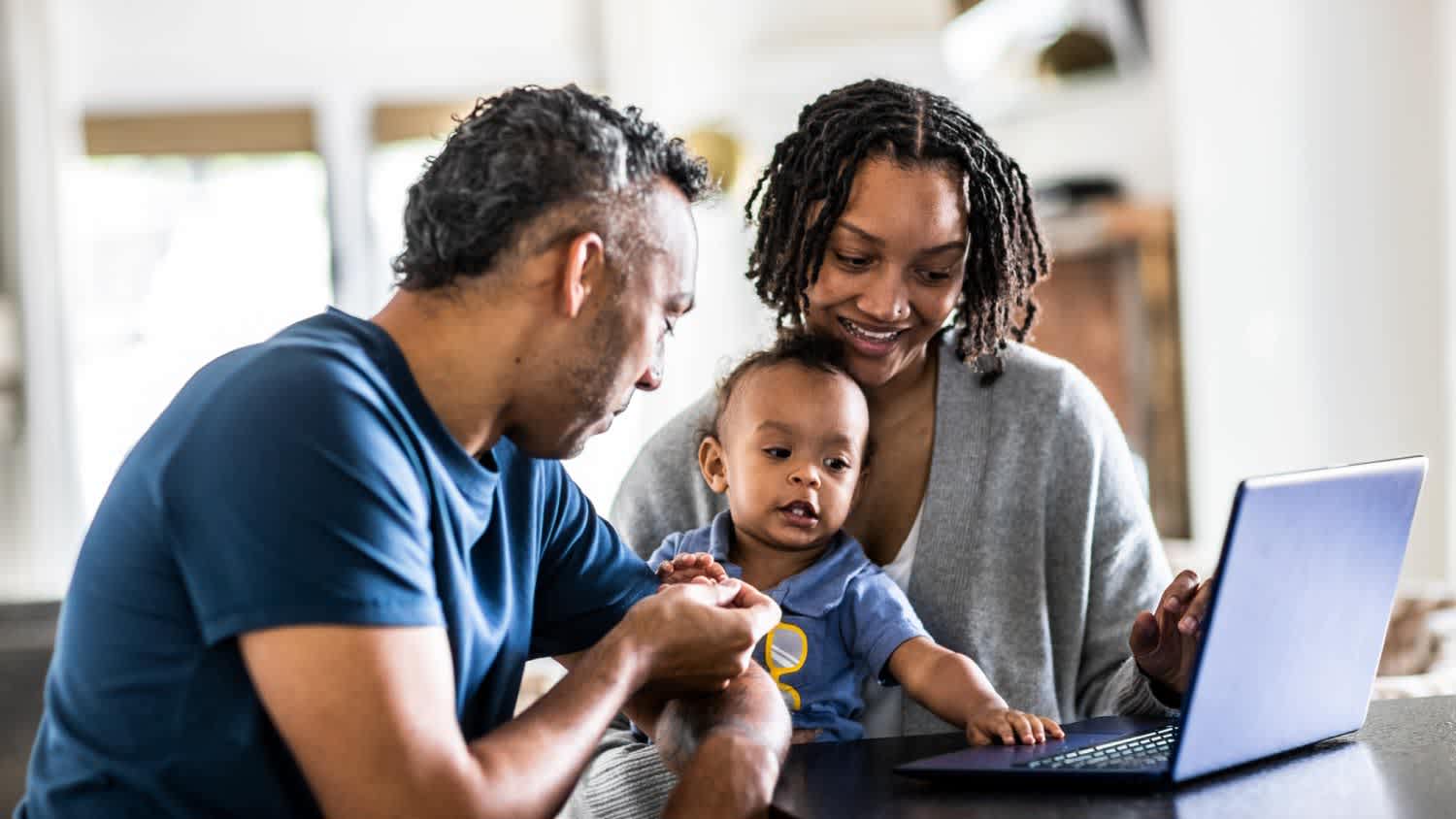 Young family using laptop at home