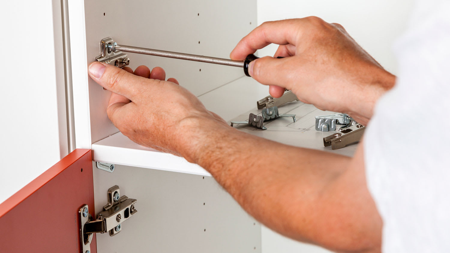 Carpenter installing new cabinet hinges