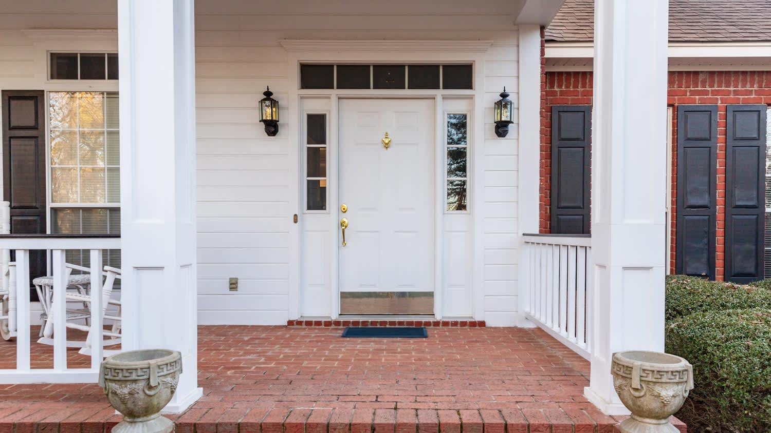 A porch with a white front door
