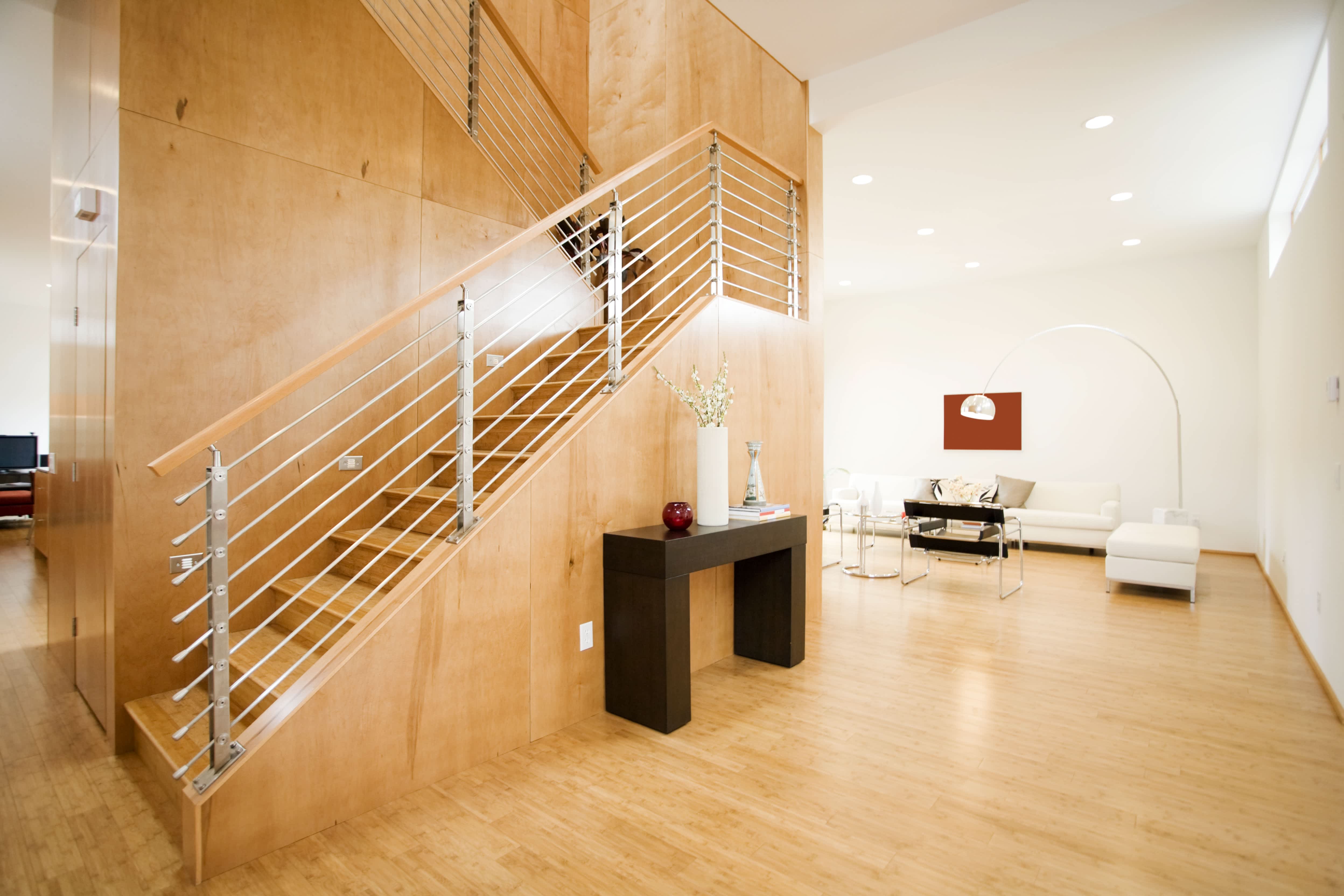 Modern living room with stainless steel cable rail system on wooden staircase