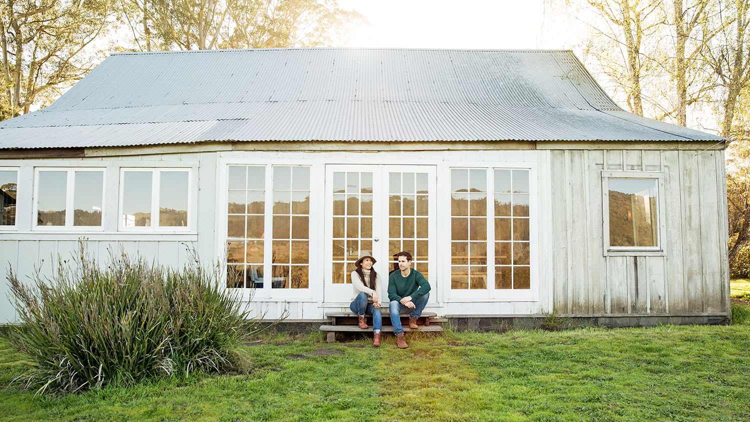 couple in front of white farmhouse home