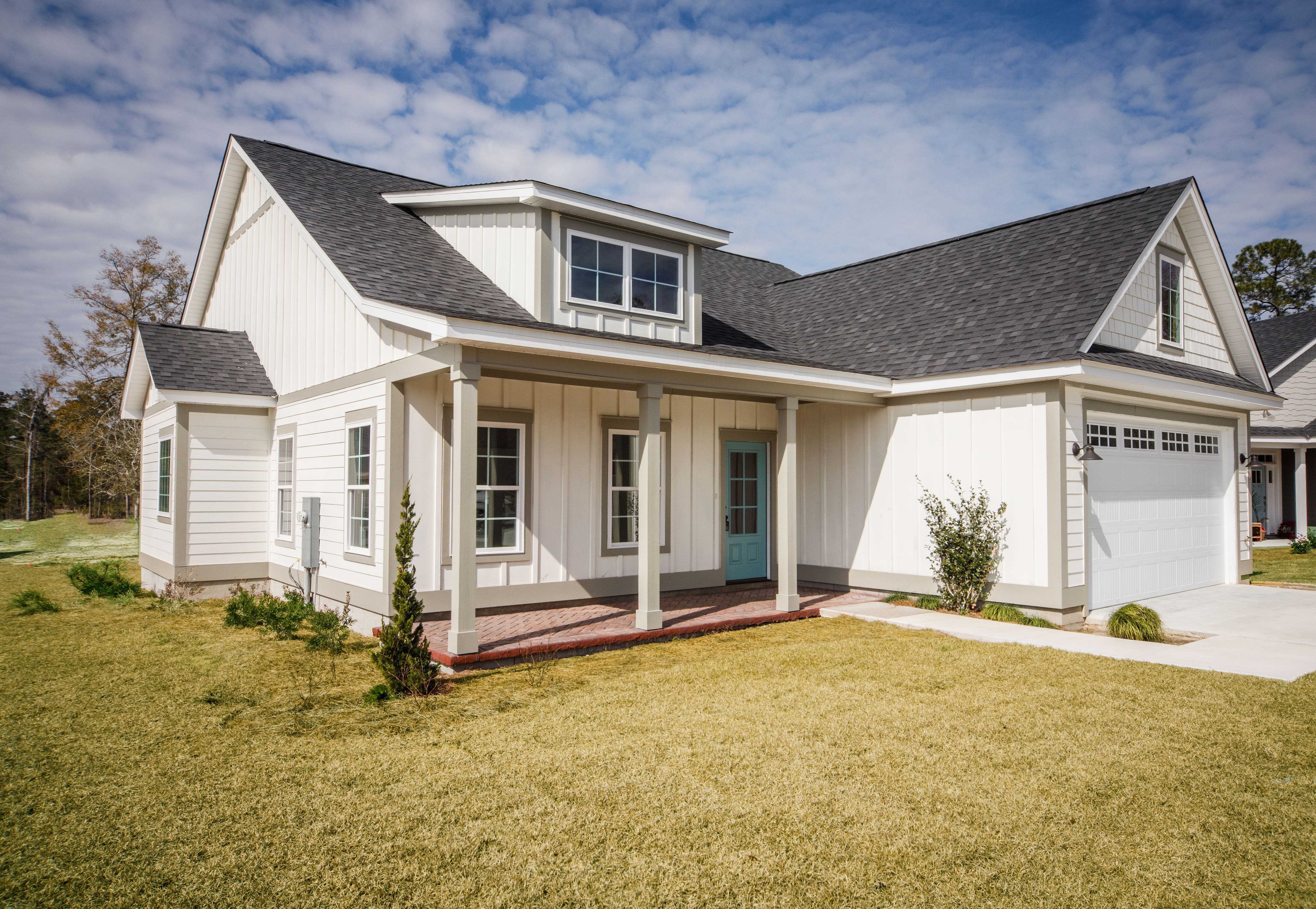 Modern farmhouse home with gray-and-white window trim and turquoise door