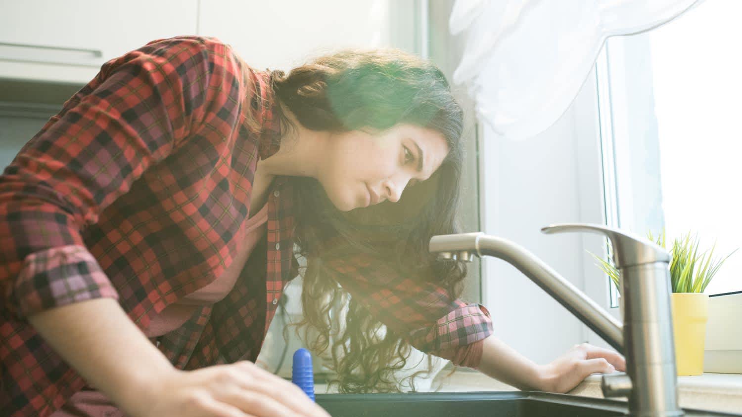 A woman checking faucet